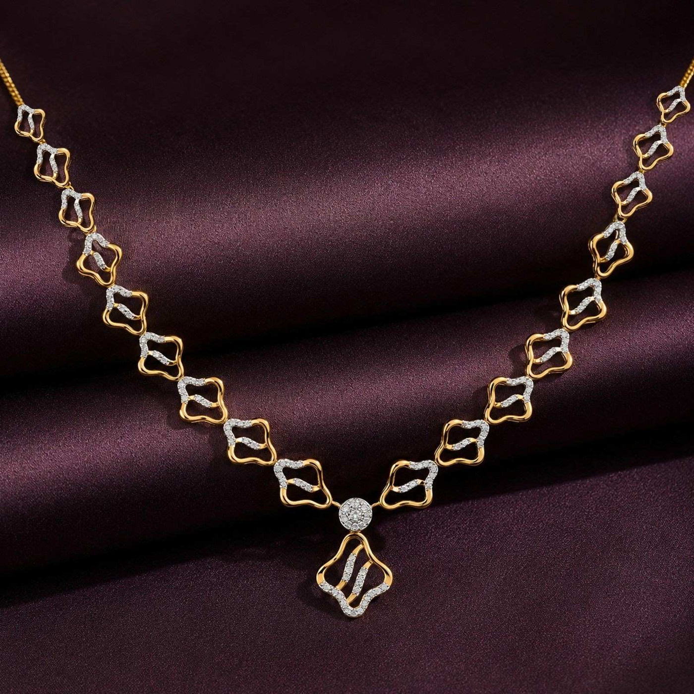 Gold and diamond necklace on a purple fabric background