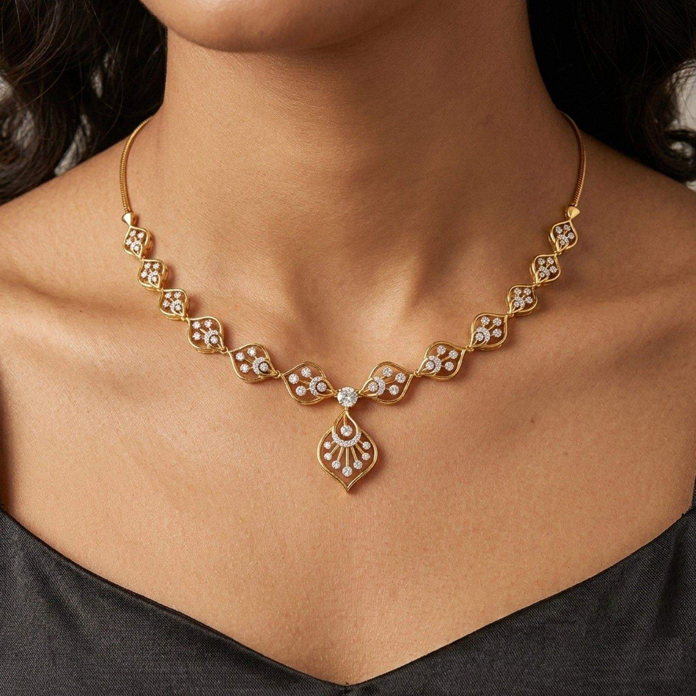 Gold necklace with diamond-like stones on a person wearing a black dress.