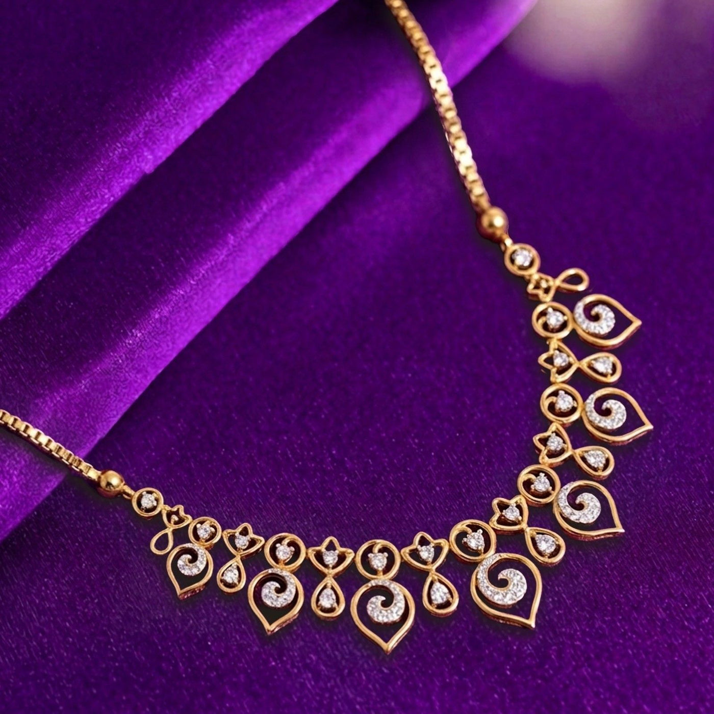Gold necklace with diamond accents on a purple fabric background