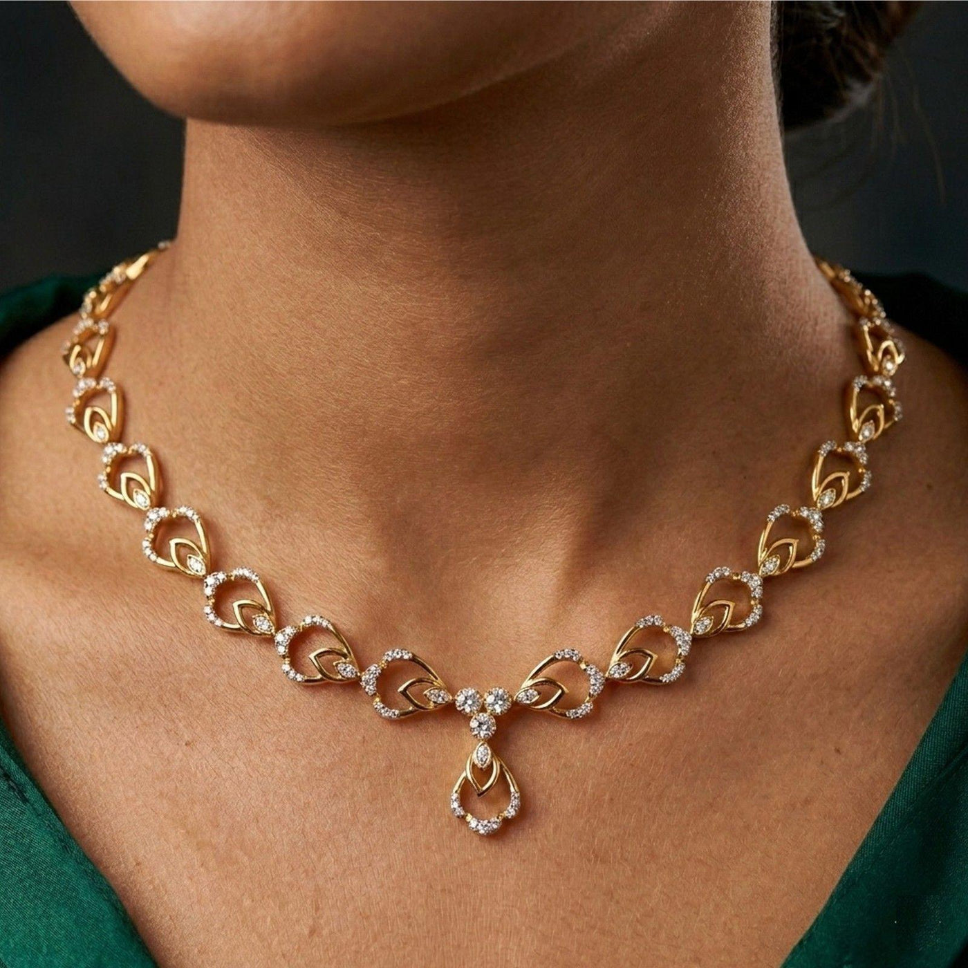 Gold necklace with diamond accents worn by a person against a dark background