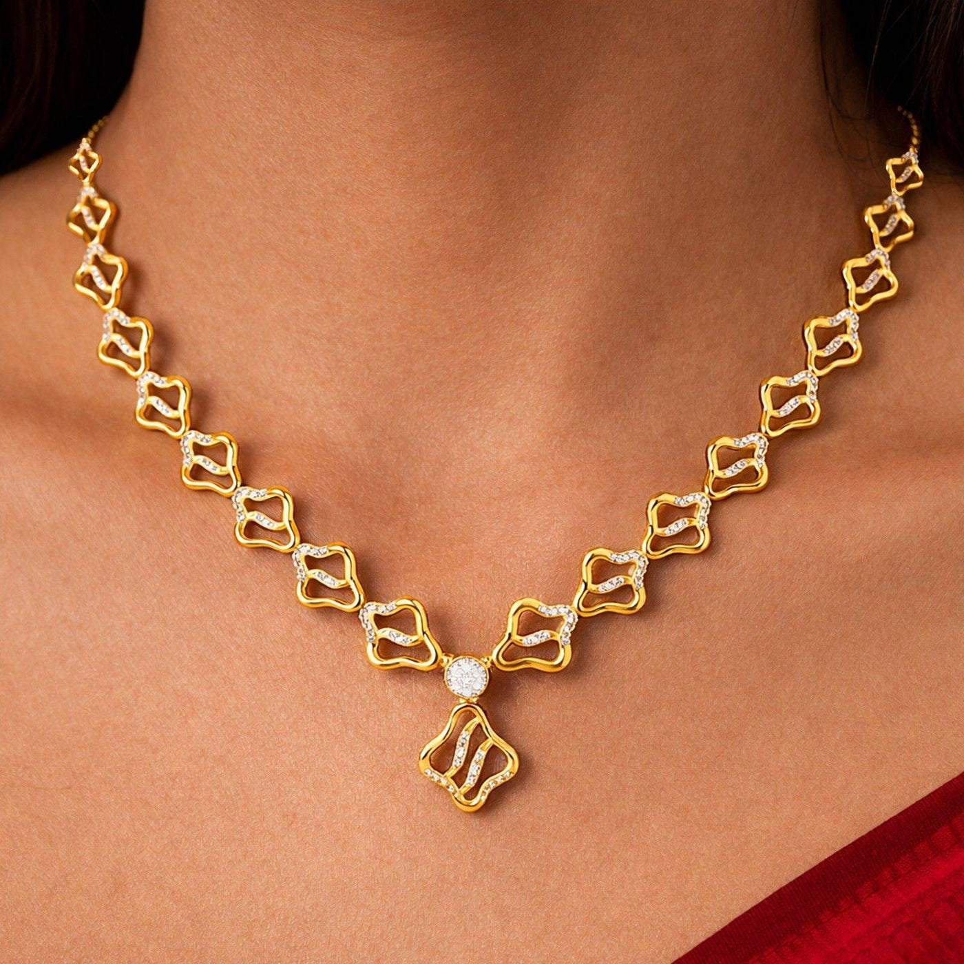 Gold necklace with diamond accents on a person's neck