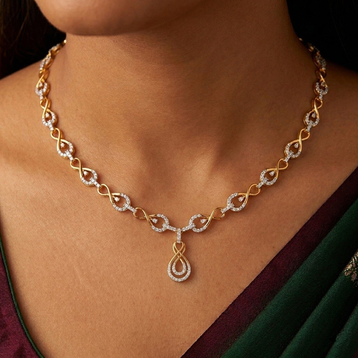 Gold necklace with a diamond on a person wearing a green saree.