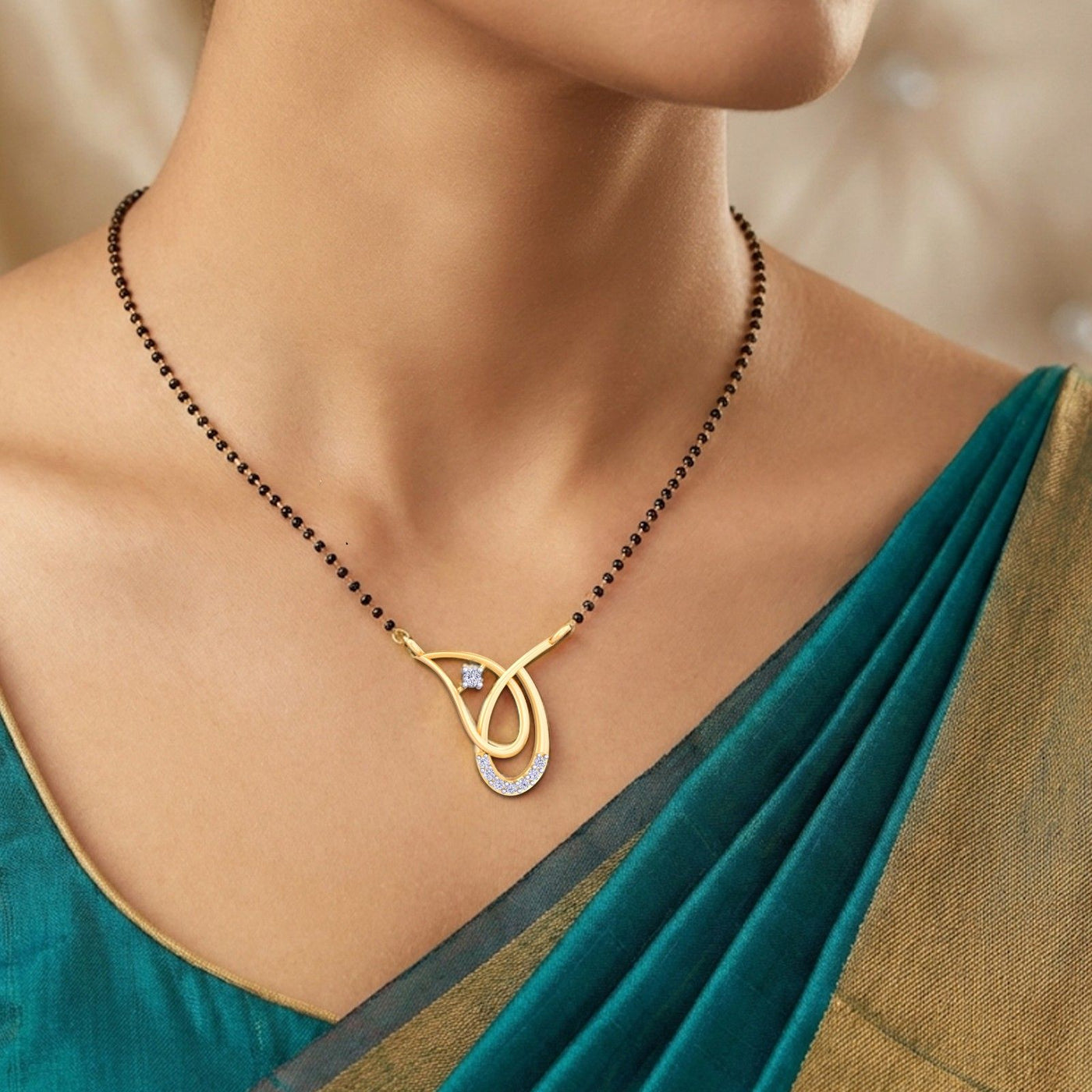 Woman wearing a gold pendant with a green saree