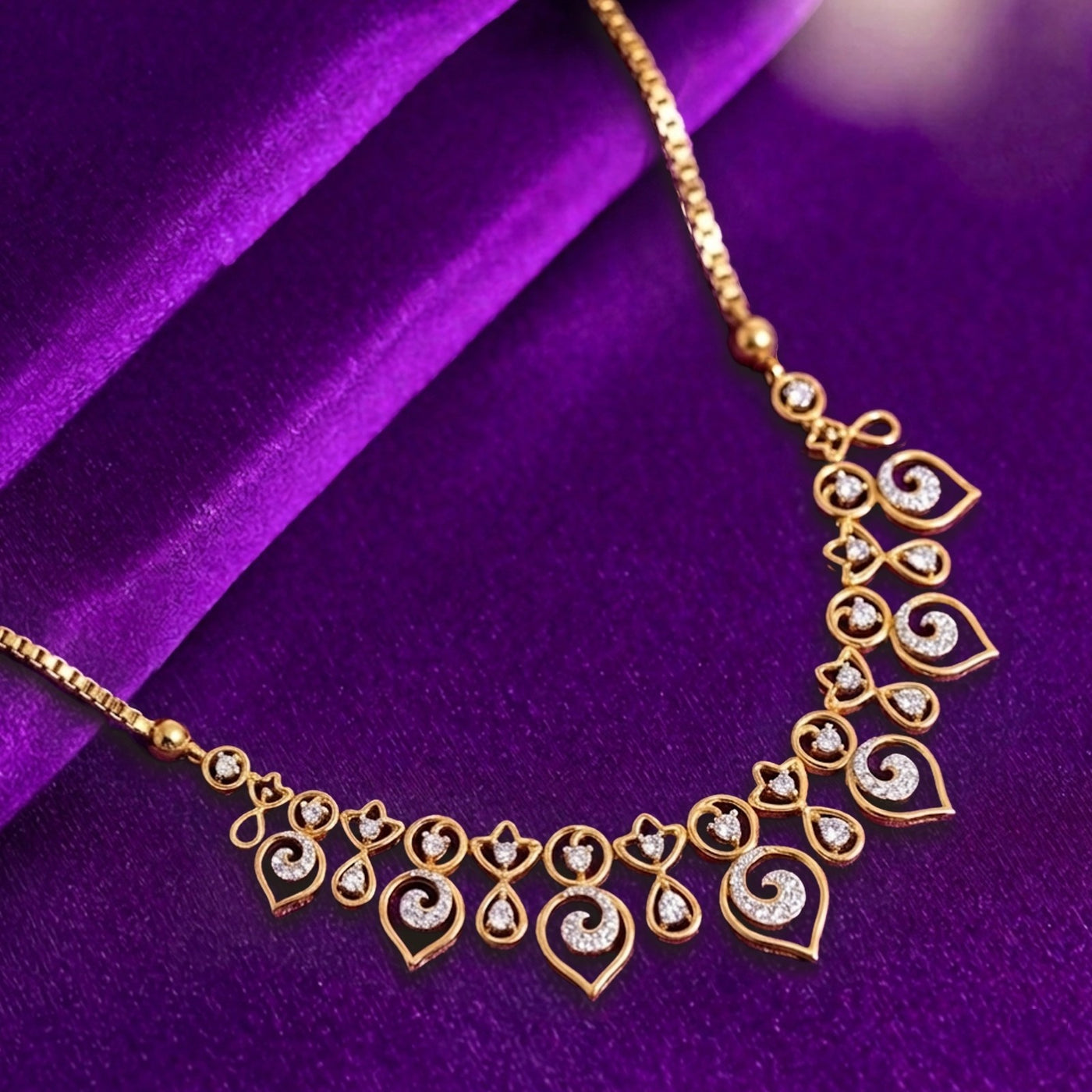 Gold necklace with diamond accents on a purple fabric background