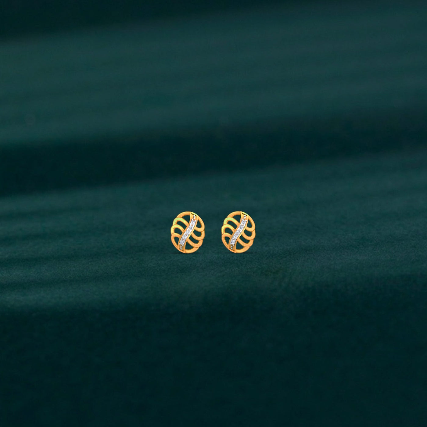 Gold and diamond earrings with circular design on a teal fabric background.