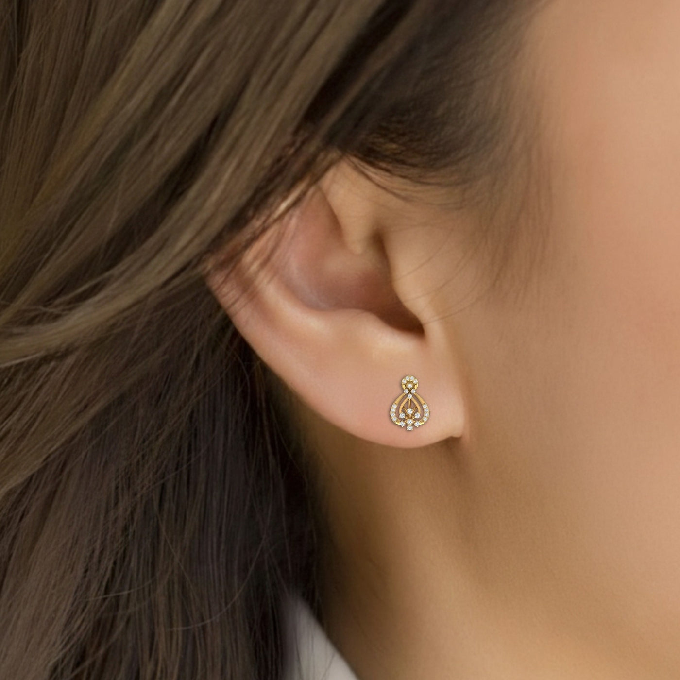 Close-up shot of a gold and diamond stud earring.