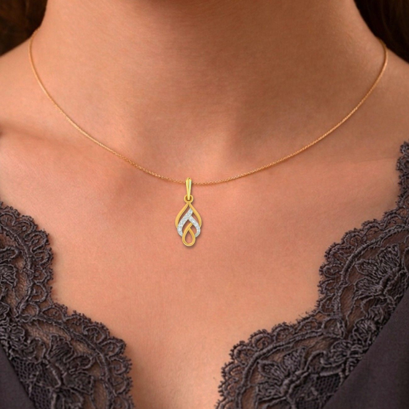 Gold necklace with a pendant on a person wearing a black lace top.