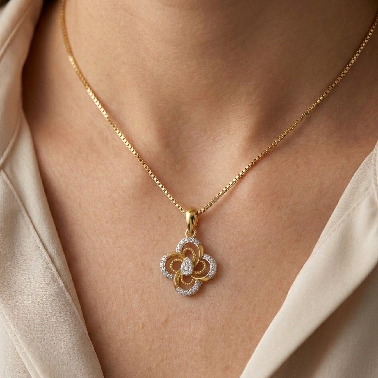 Designer gold and diamond pendant featuring a graceful floral pattern with brilliant diamond accents.