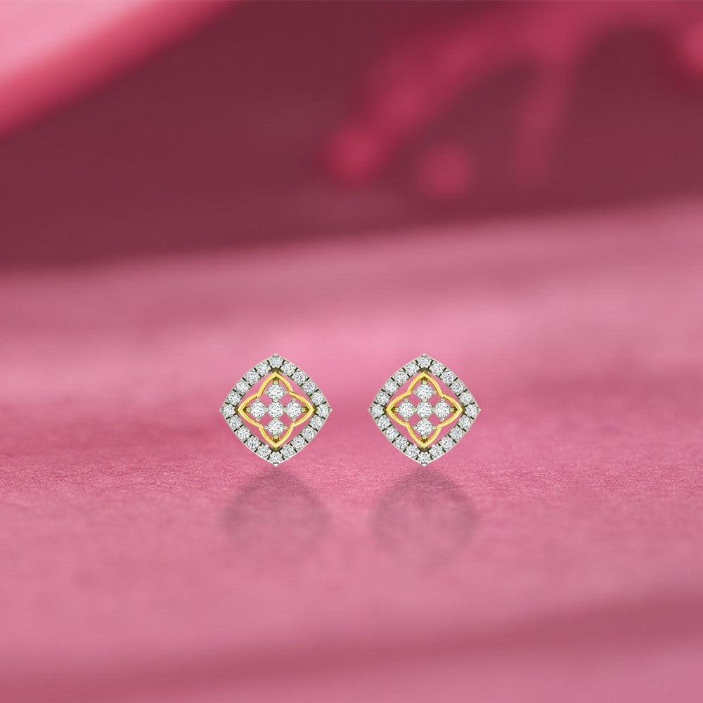 Pair of gold and diamond stud earrings on a pink  background.