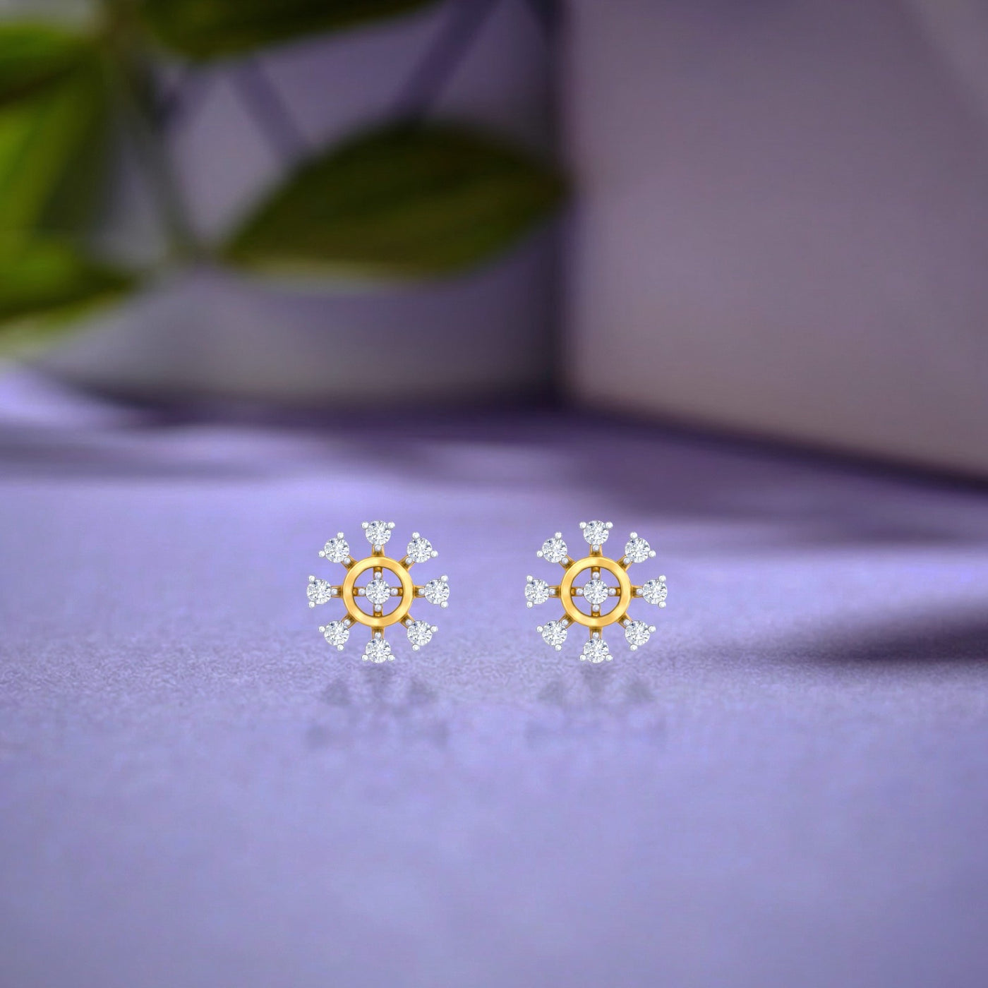 Gold and diamond stud earring with floral-design on a purple surface. 