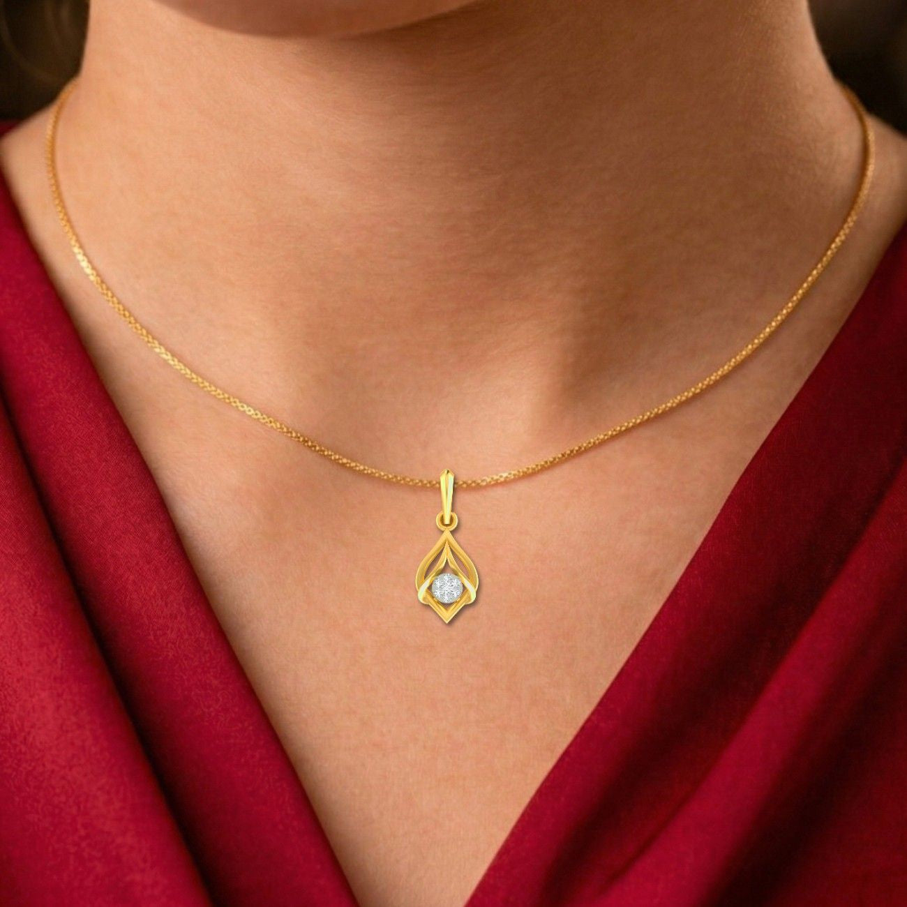 Gold necklace with a pendant on a person wearing a red garment