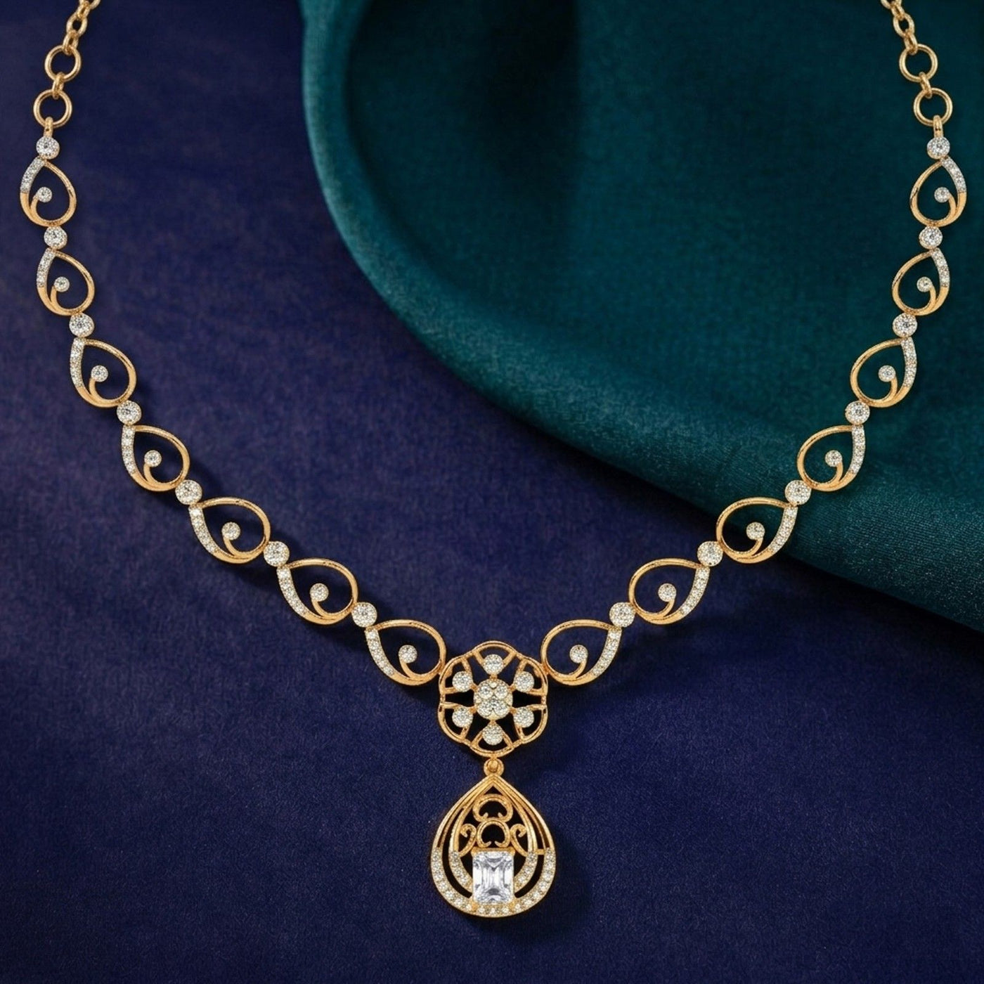 Gold and diamond necklace with floral on a blue and teal surface.