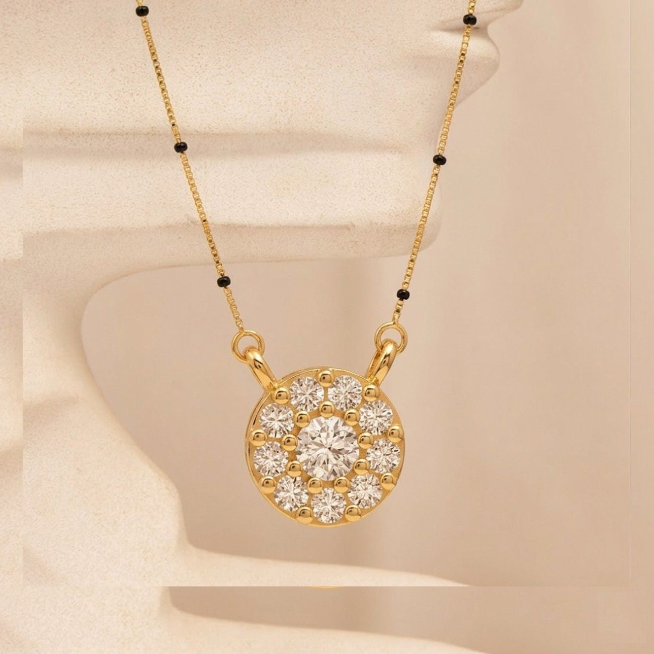 Yellow gold and diamond mangalsutra on baige  background