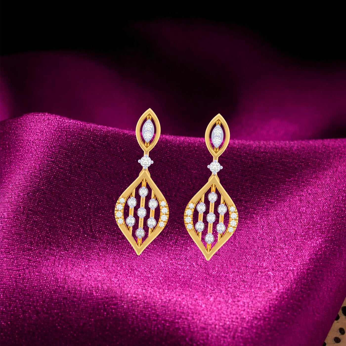 Gold and diamond drop earrings on a purple fabric background