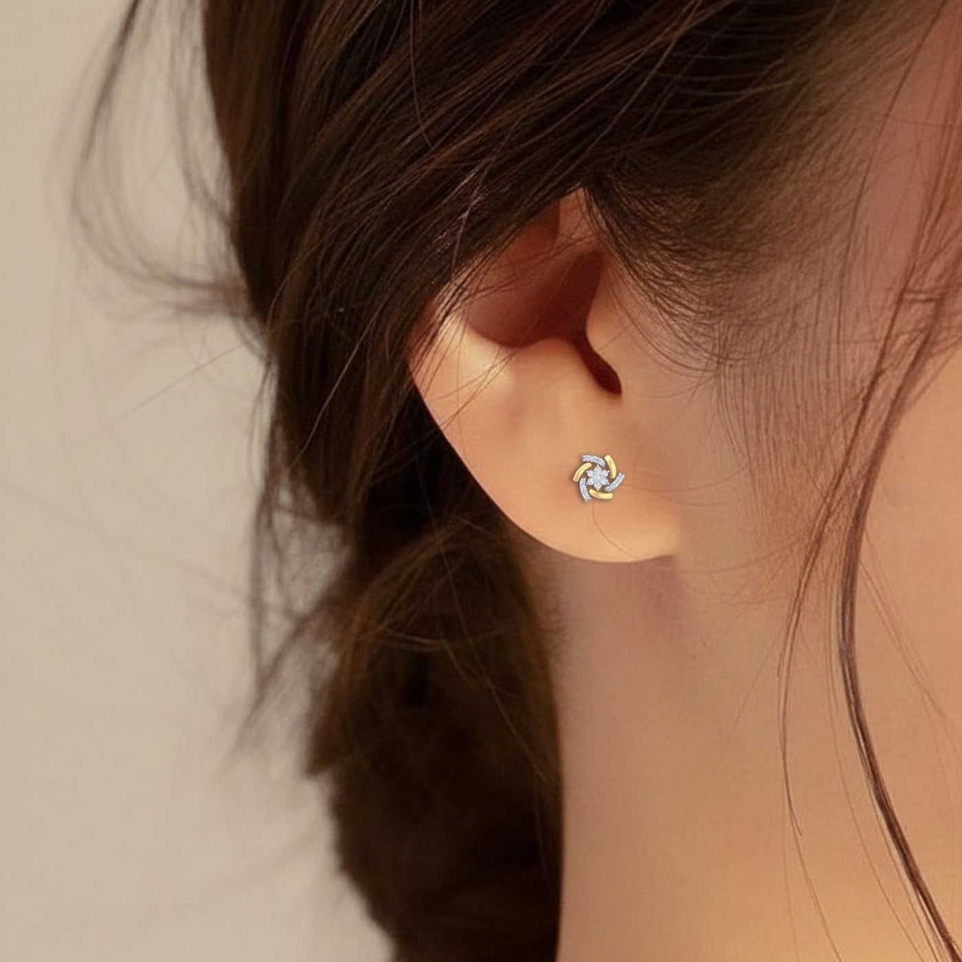Close-up shot of gold and diamond stud earring with floral-design.