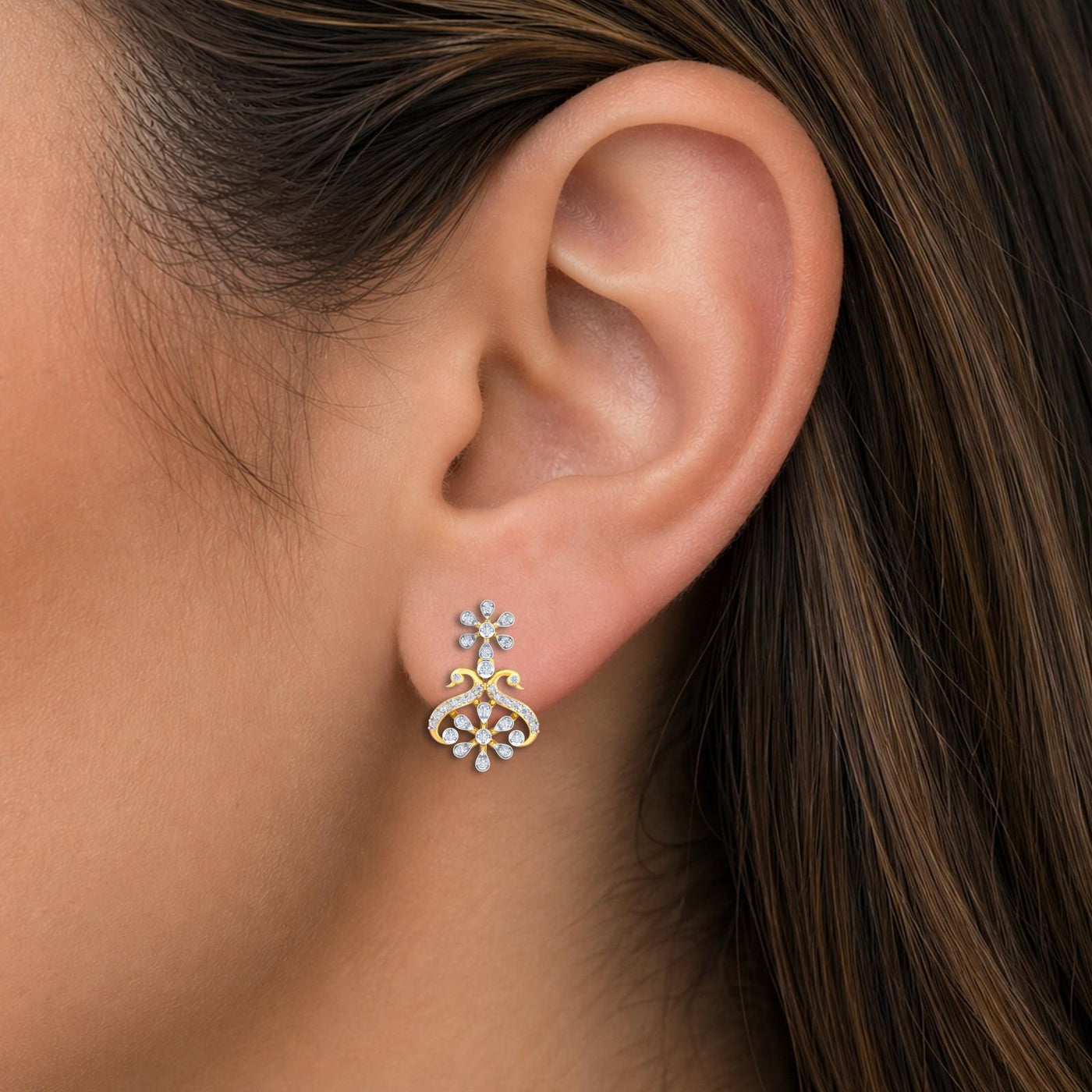 Close-up shot of a gold and diamond floral-shaped drop earrings.