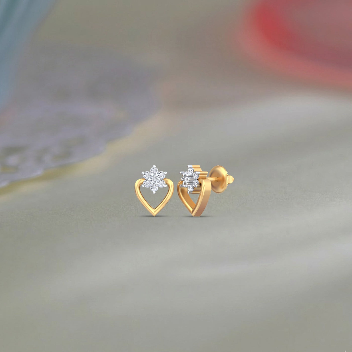 Gold and diamond heart-shaped stud earrings on a blurred background