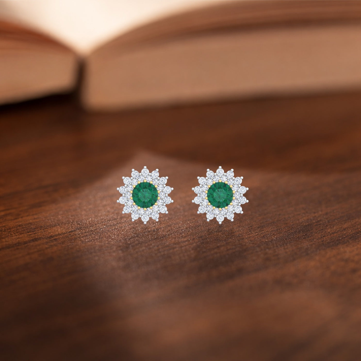 Gold and diamond stud earrings with emerald gemstone on a wooden surface.