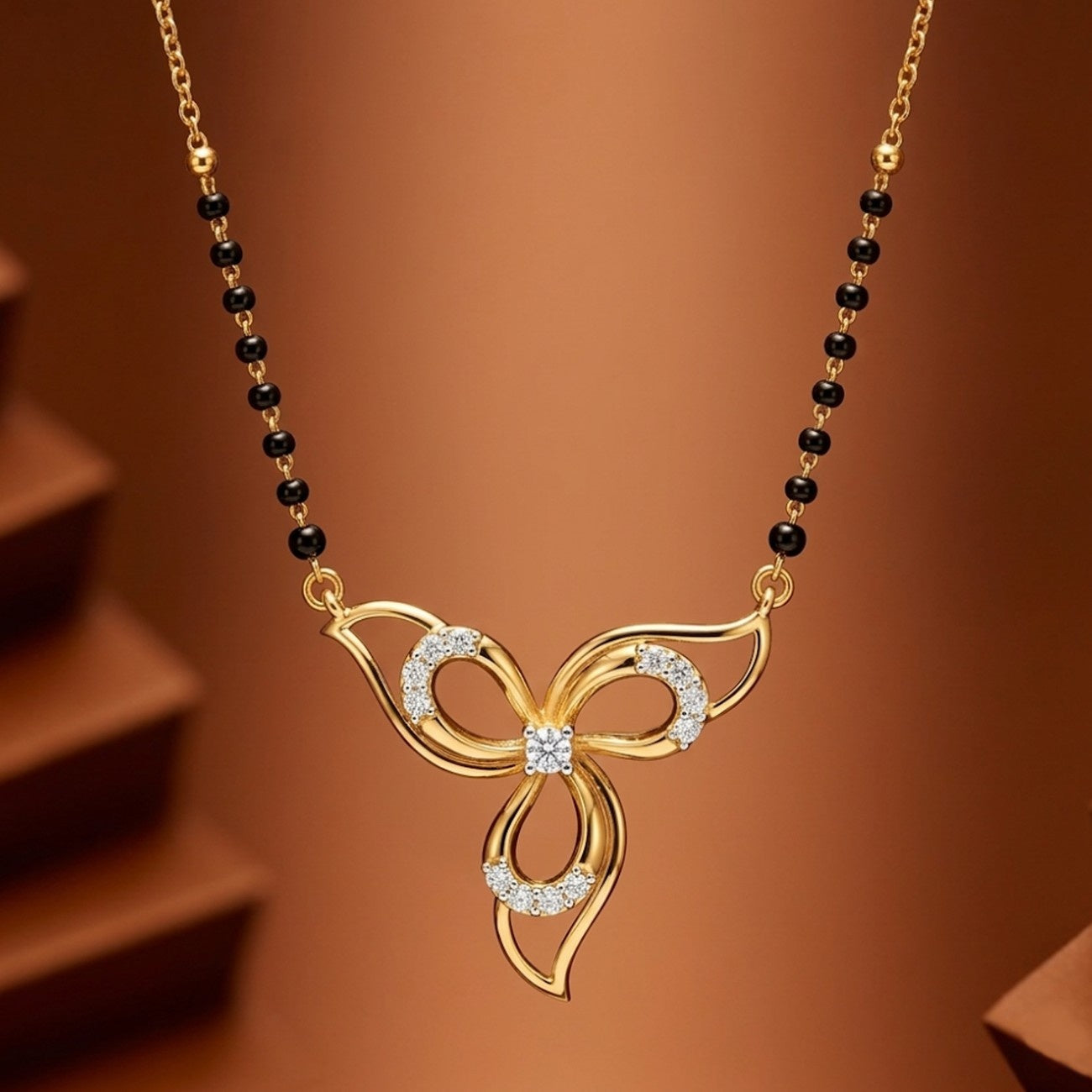 Yellow Gold and diamond butterfly mangalsutra on a black beaded against a brown background