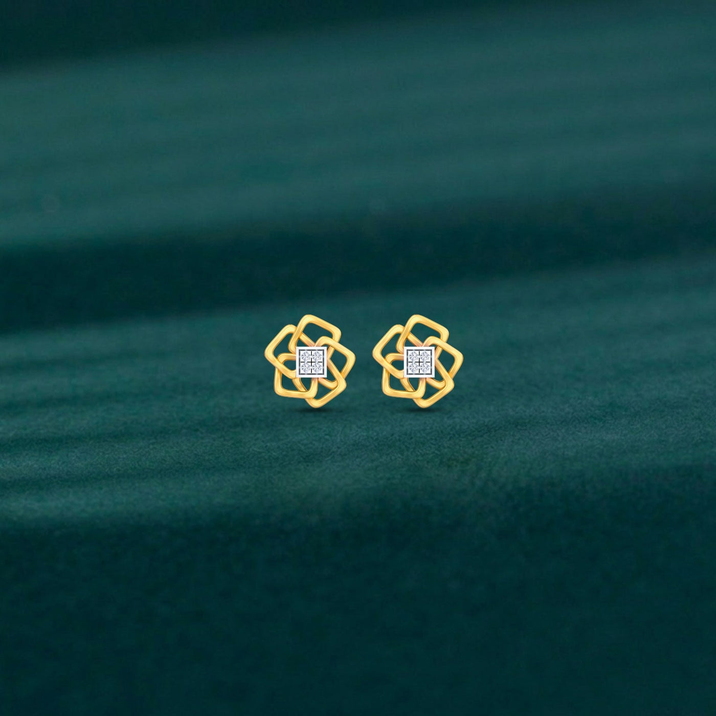 Gold and diamond floral stud  earrings on a teal fabric background