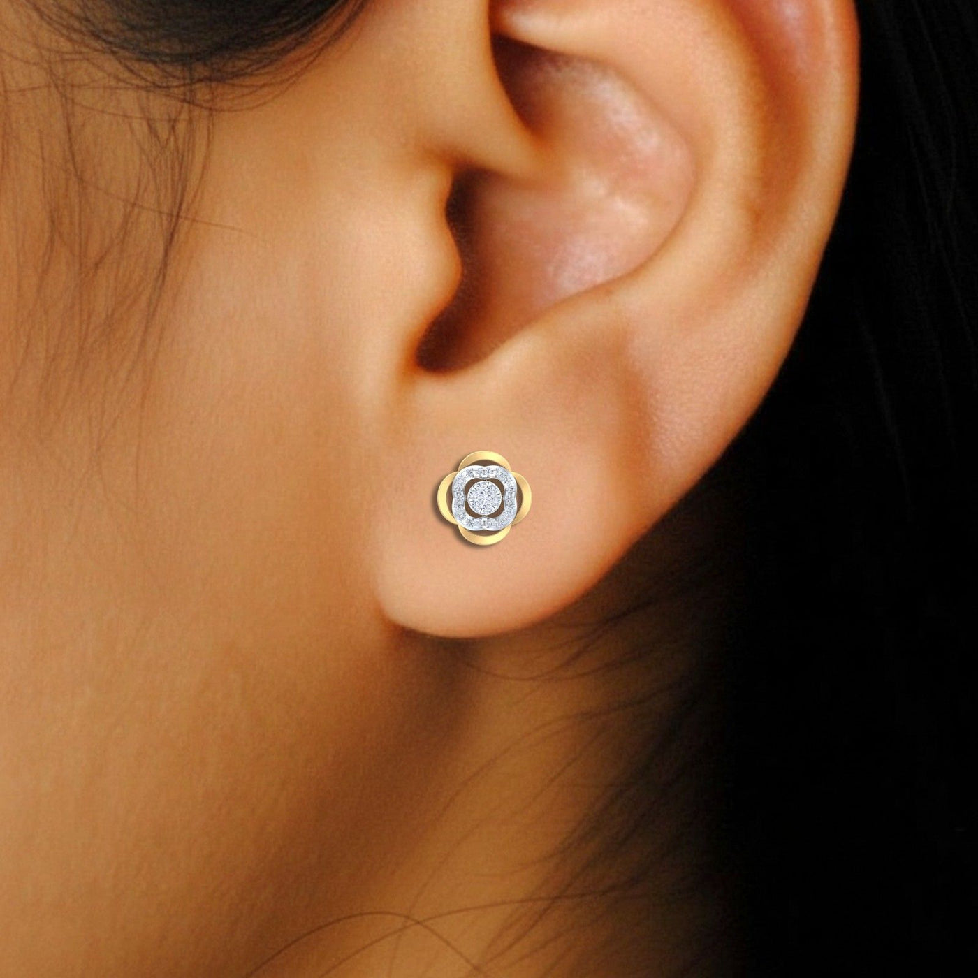 Close-up shot of a Pair of gold and diamond floral-design stud earrings.