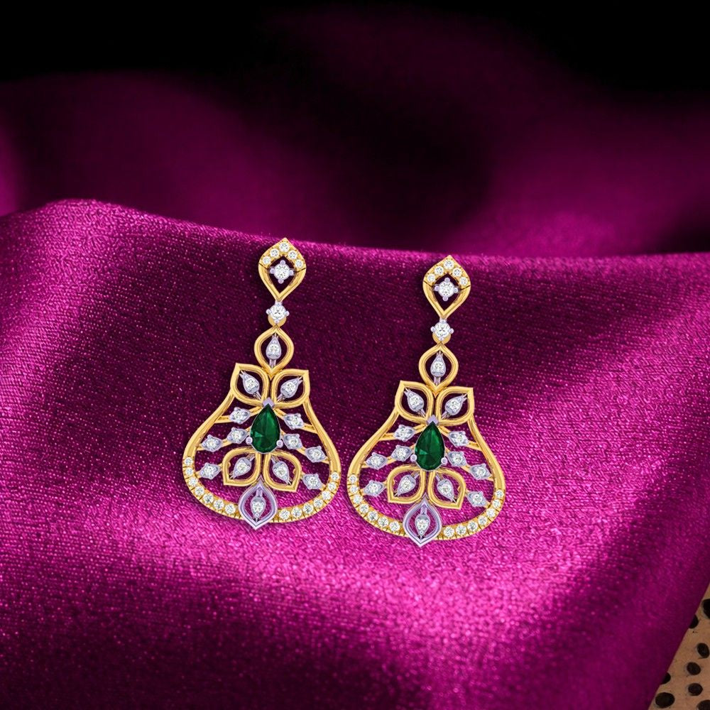 Gold and diamond earrings with clear gemstones on a magenta fabric background