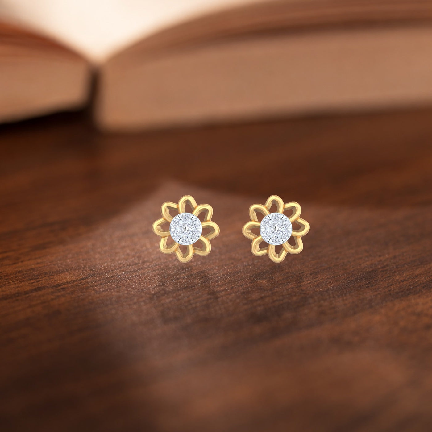 Gold and diamond stud earring with floral-design on a wooden surface.