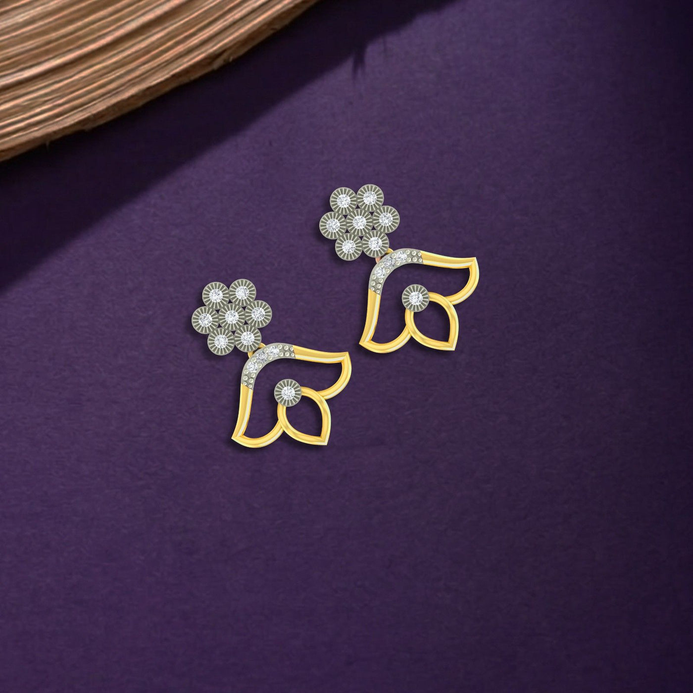 Gold and diamond stud earrings with floral designs on a purple surface