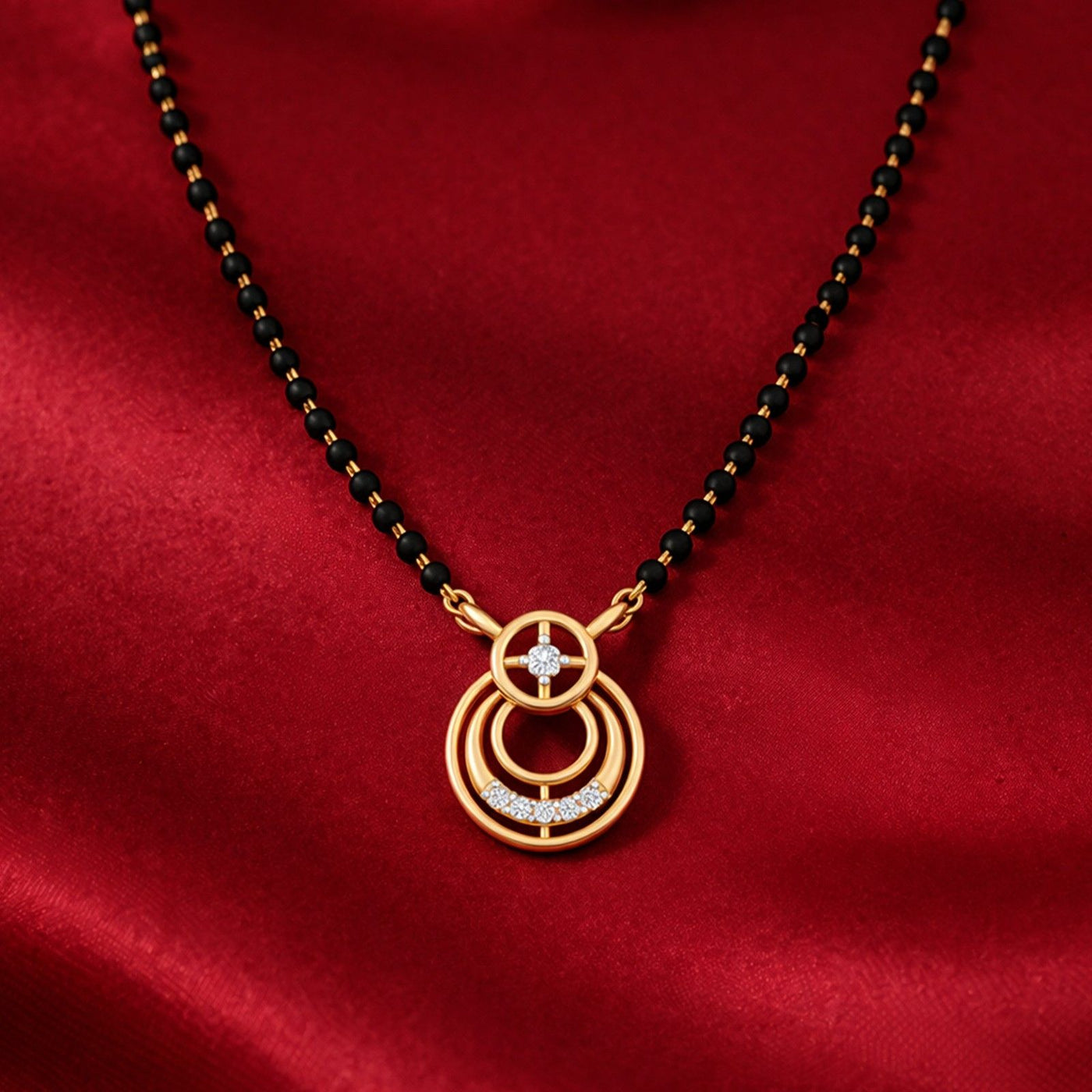 Gold mangalsutra with a circular pendant on a red fabric background