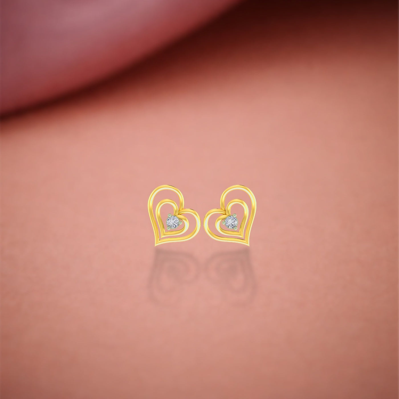 Gold and diamond heart-shaped earrings stones on a pink background