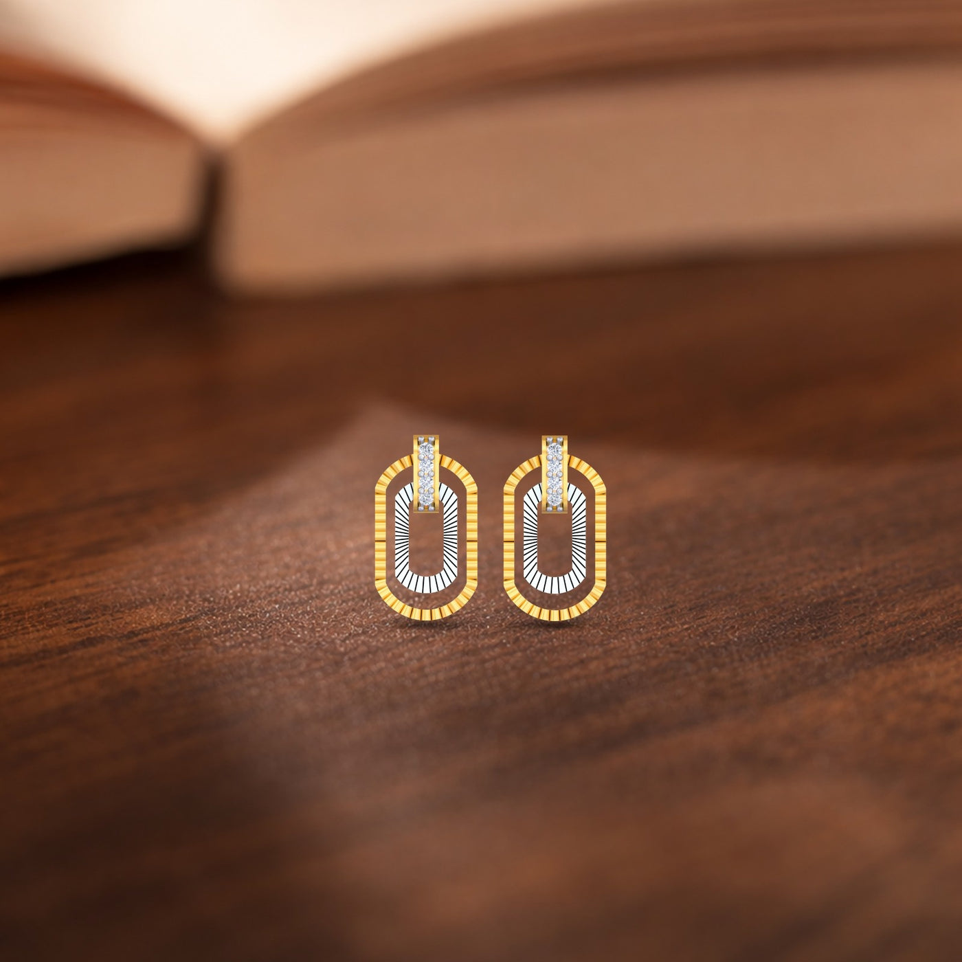 Gold and diamond stud earrings on a wooden surface.