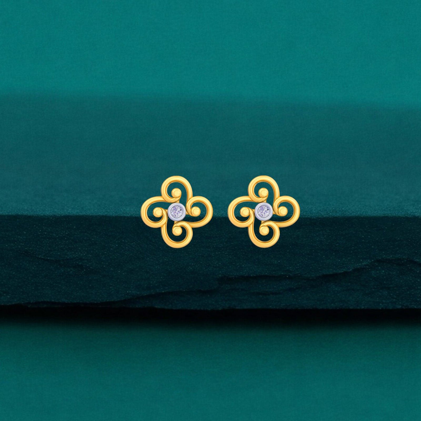 Gold and diamond floral stud earring on a white background on a teal background
