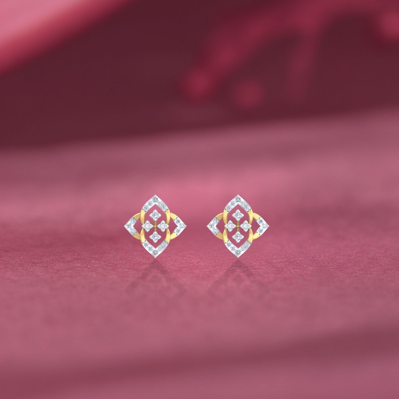 Gold and diamond stud earring with floral-design on a pink fabric background.