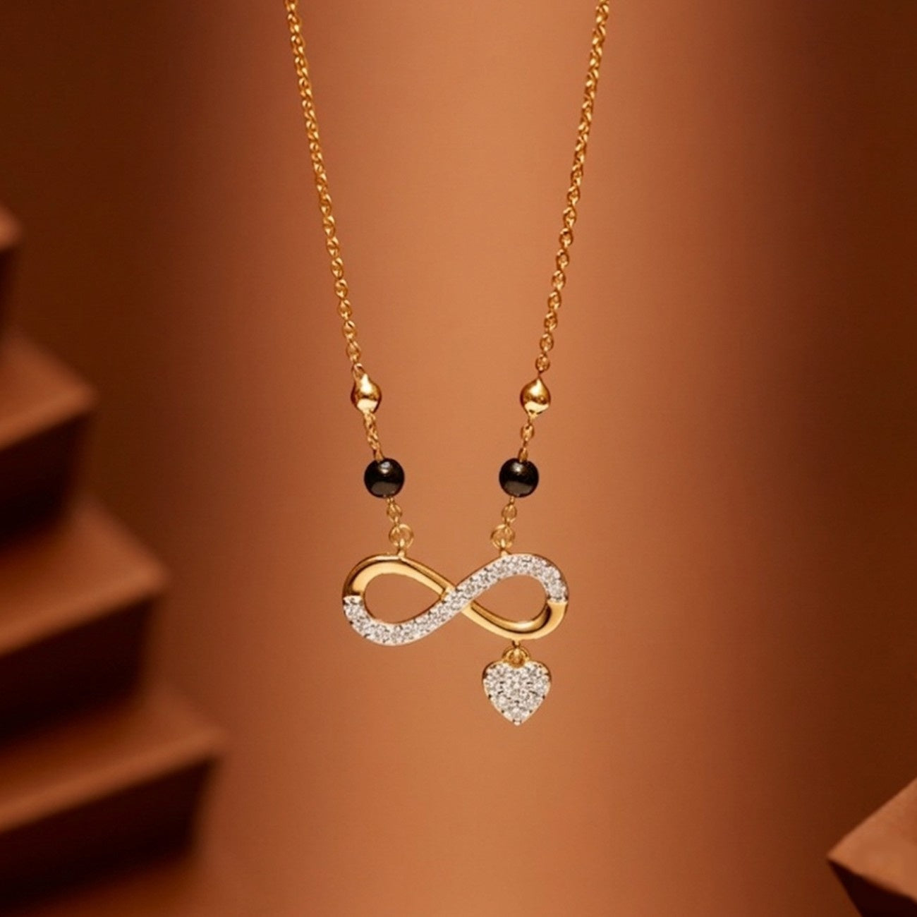 Yellow gold & diamond infinity design mangalsutra on brown background