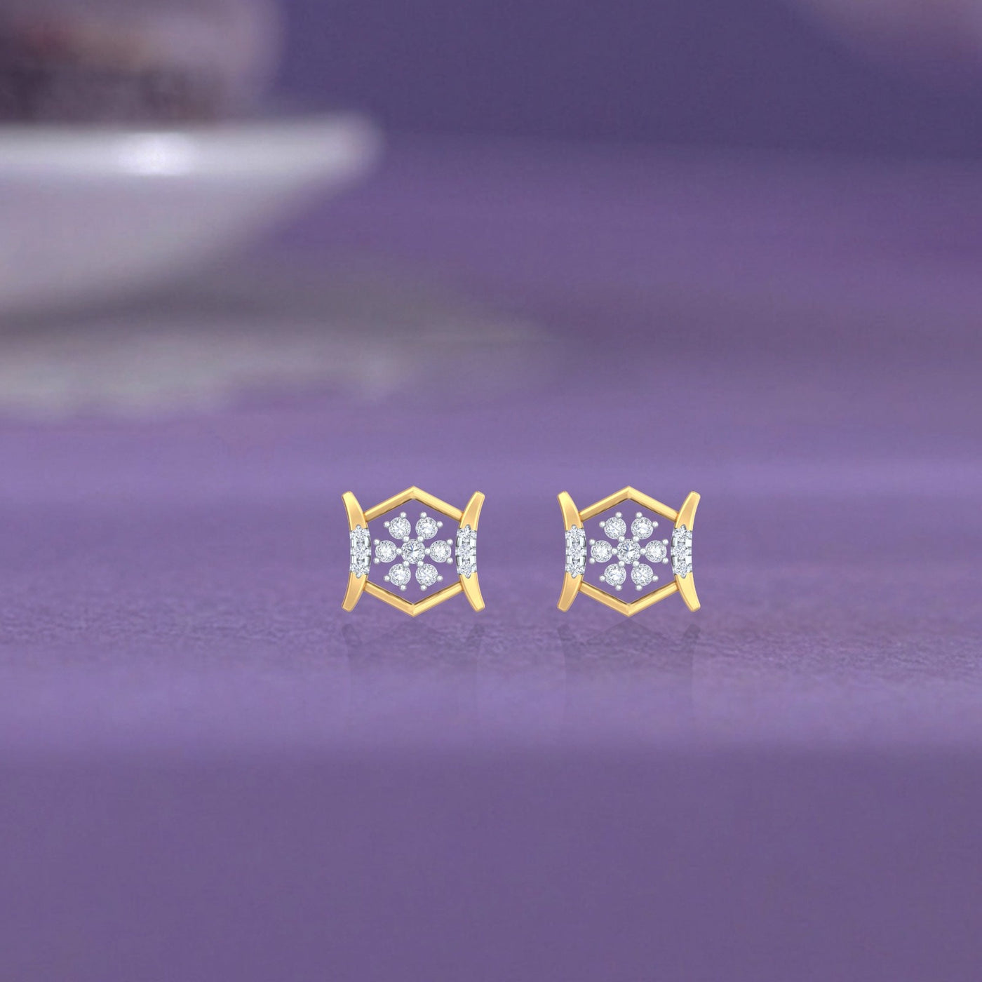 Gold and diamond stud earring on a purple surface.