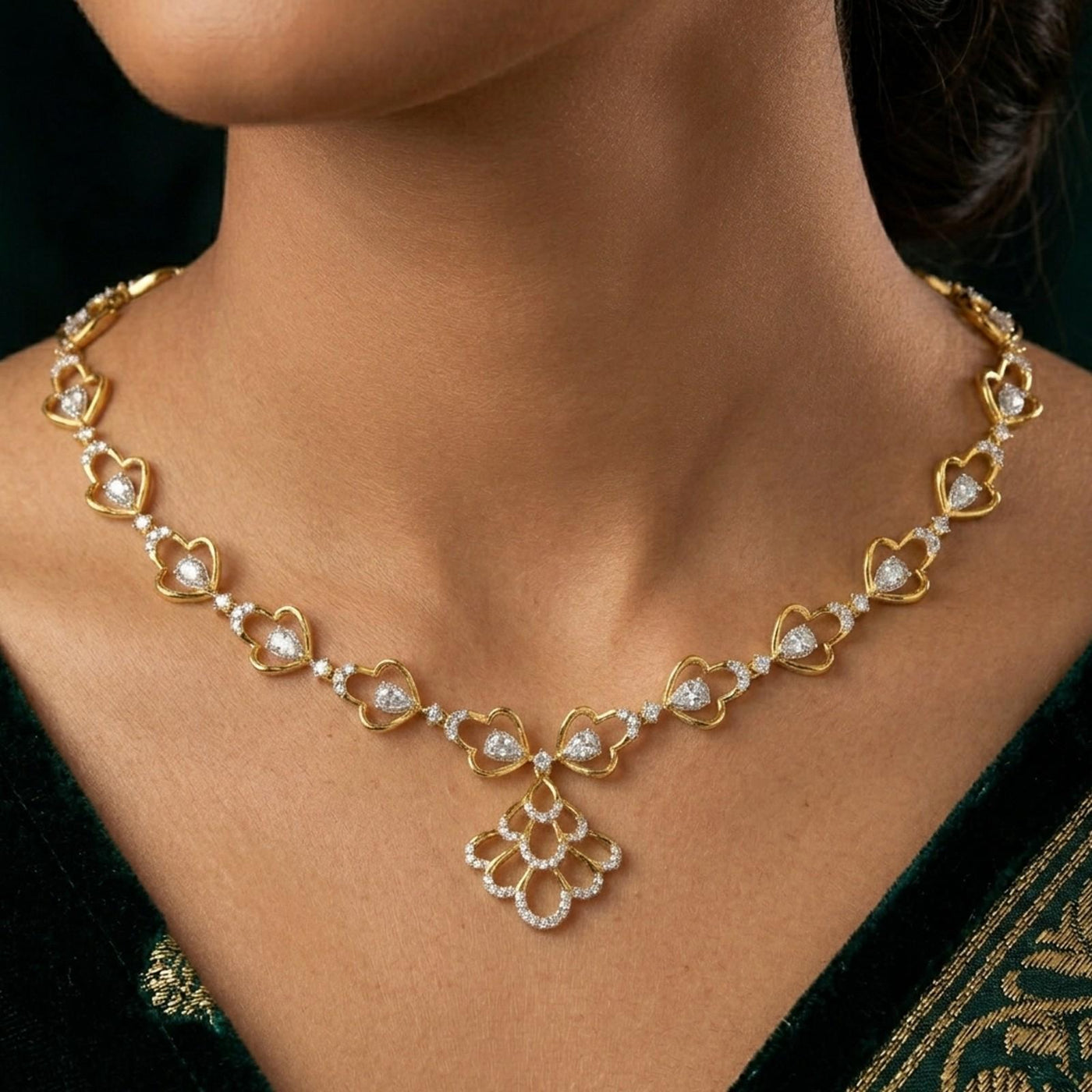 Gold necklace with floral designs on a person wearing a green saree.