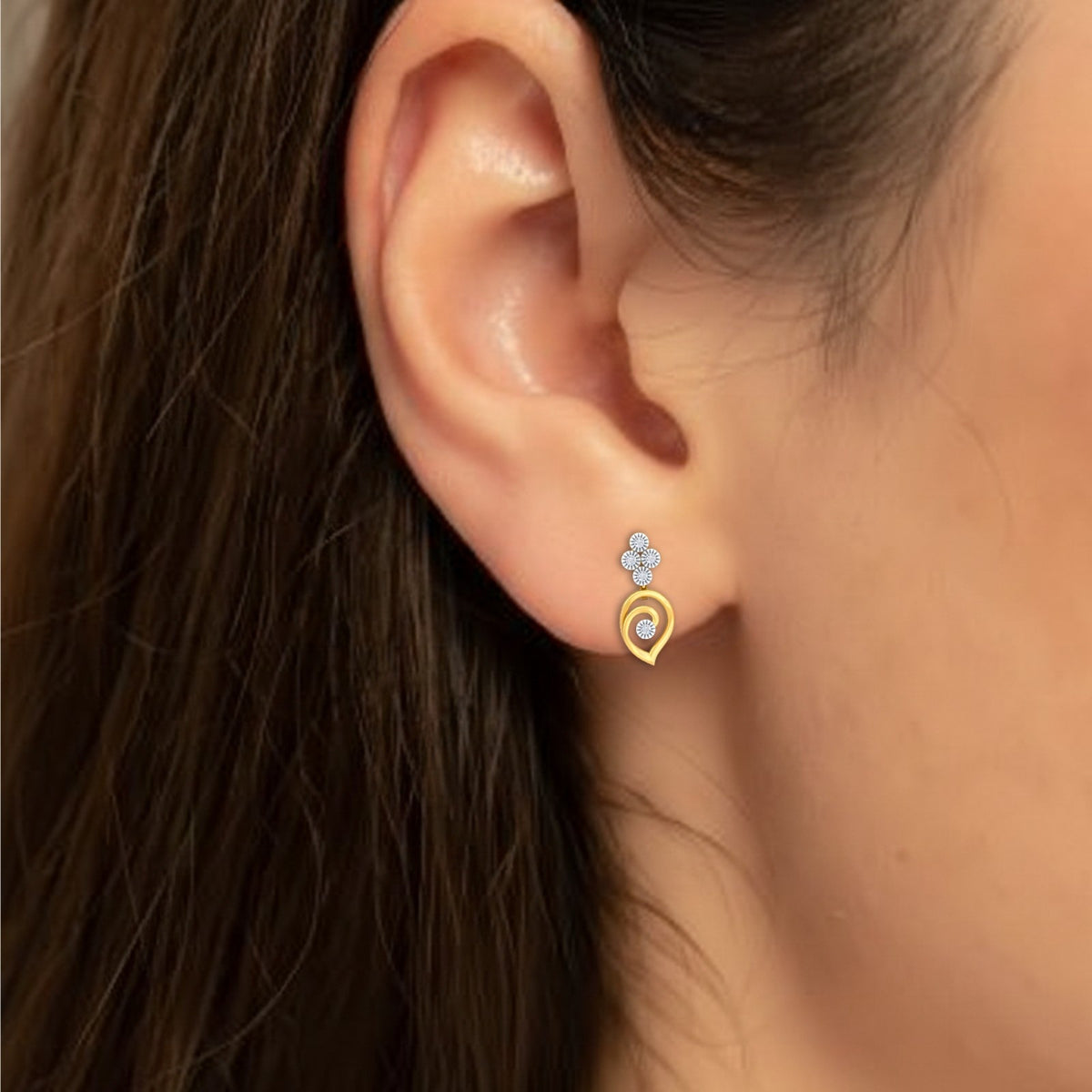 Close-up shot of a gold and diamond drop earrings.