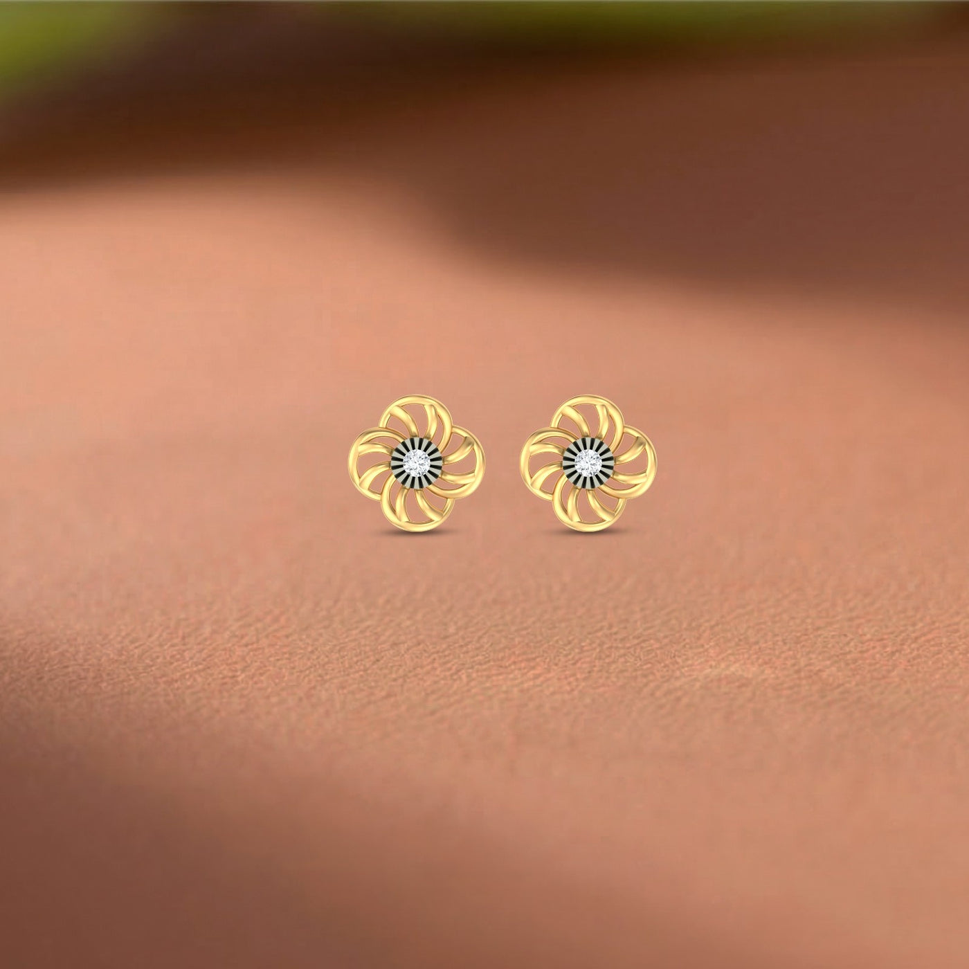 Gold and diamond stud earrings with floral design on a orange white background