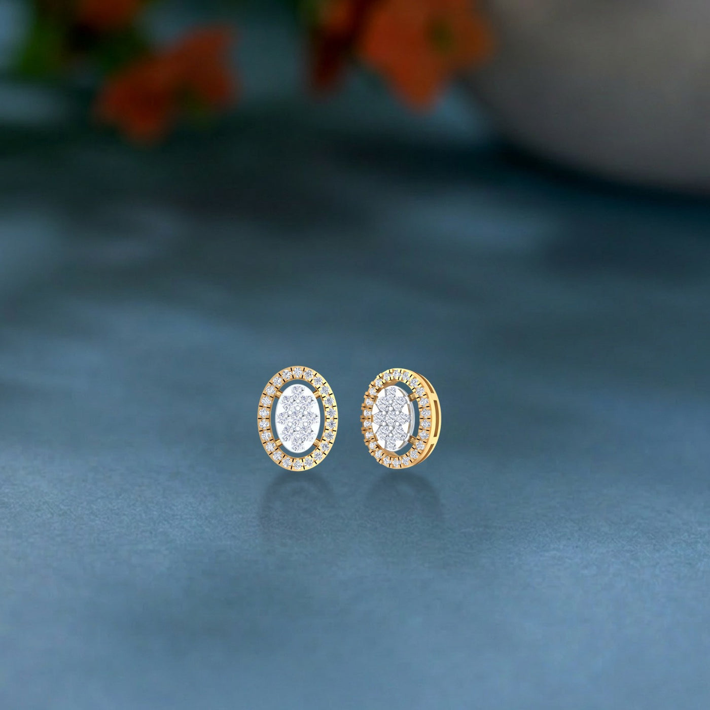 A pair of gold earrings encrusted with sparkling diamonds, designed in a circular shape on a blue background.