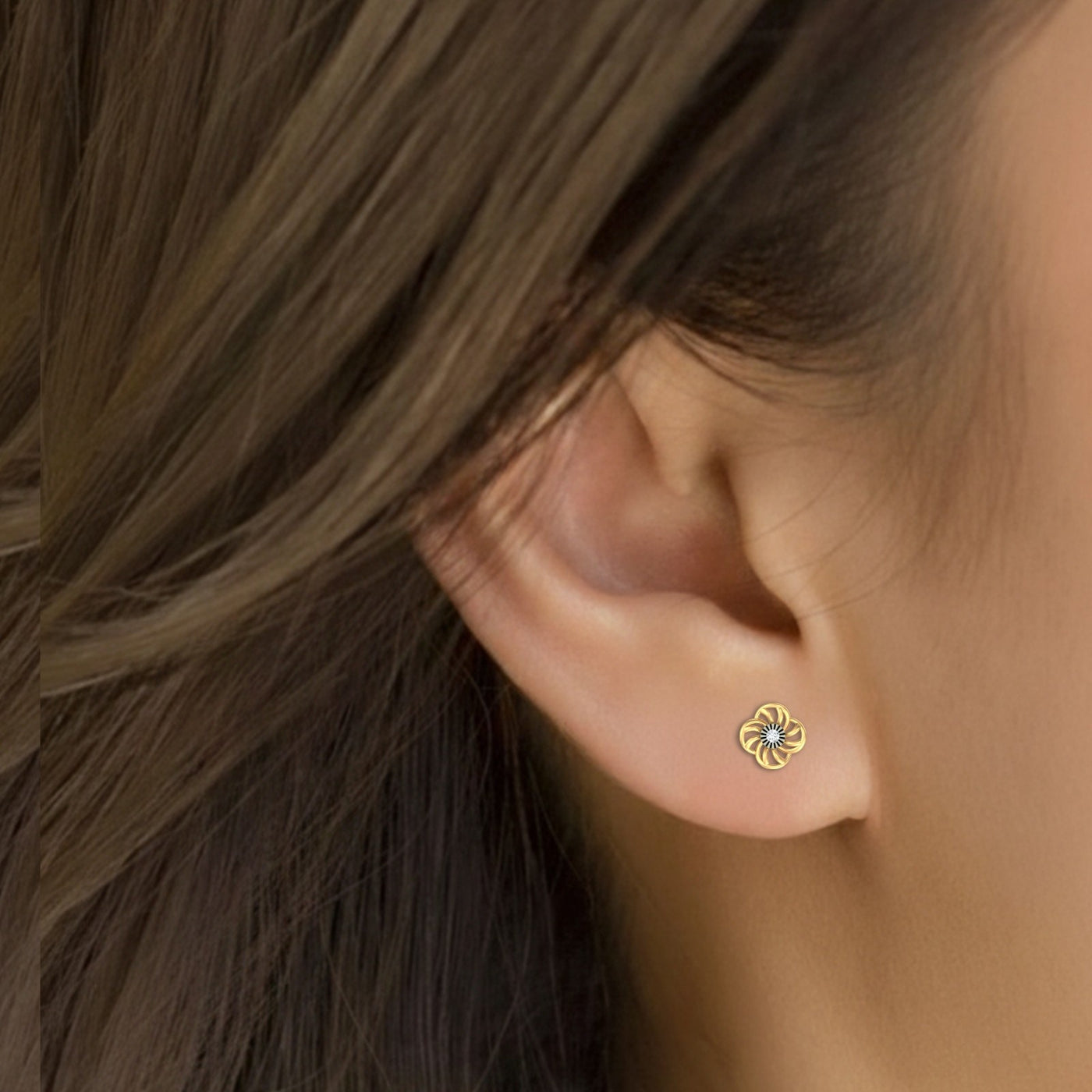 Close-up shot of a gold and diamond floral stud earrings.