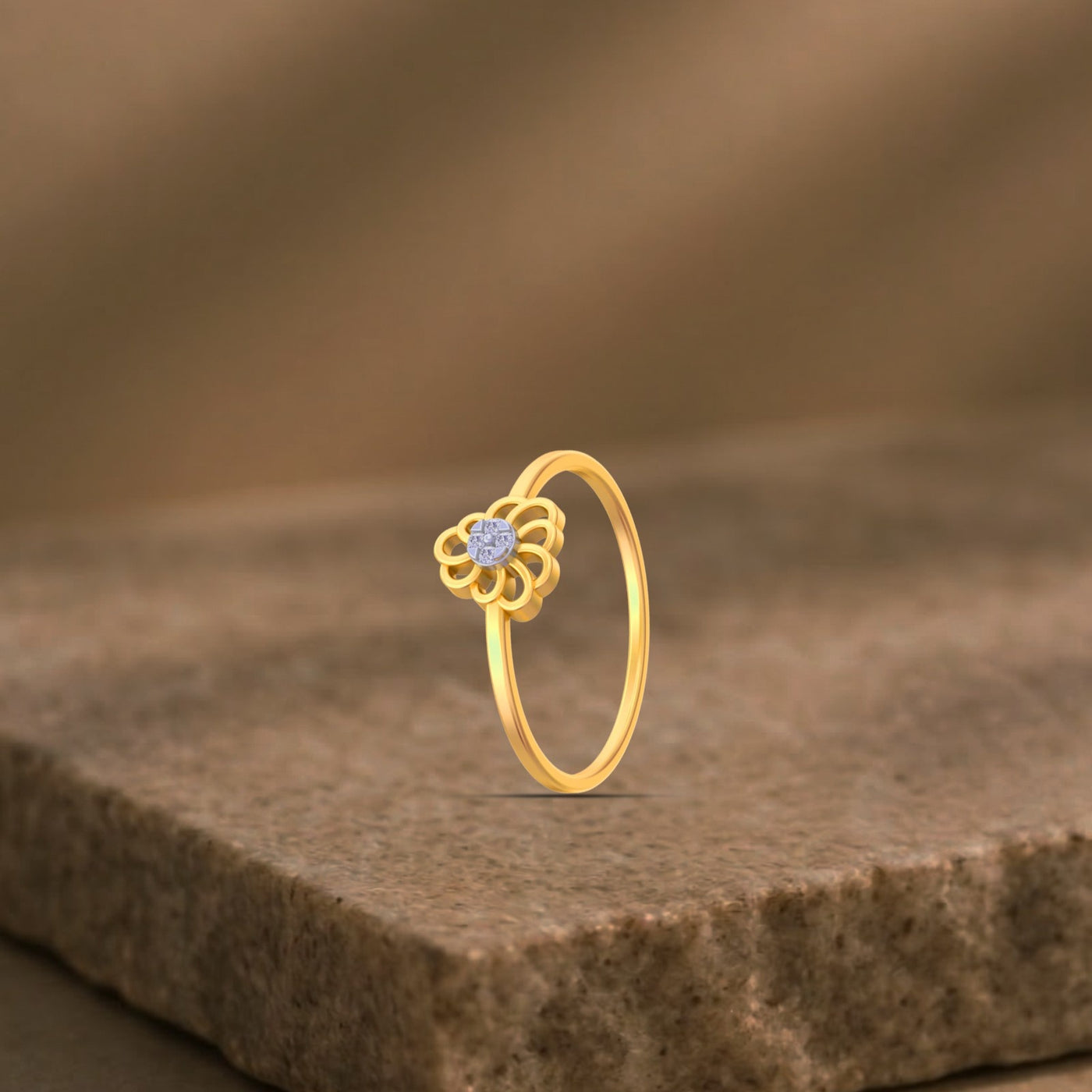 Gold ring with a small blue gemstone on a brown surface