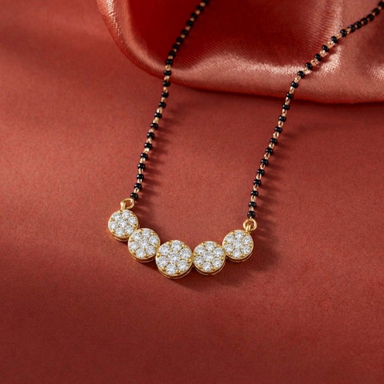 gold and diamond round mangalsutra on red background