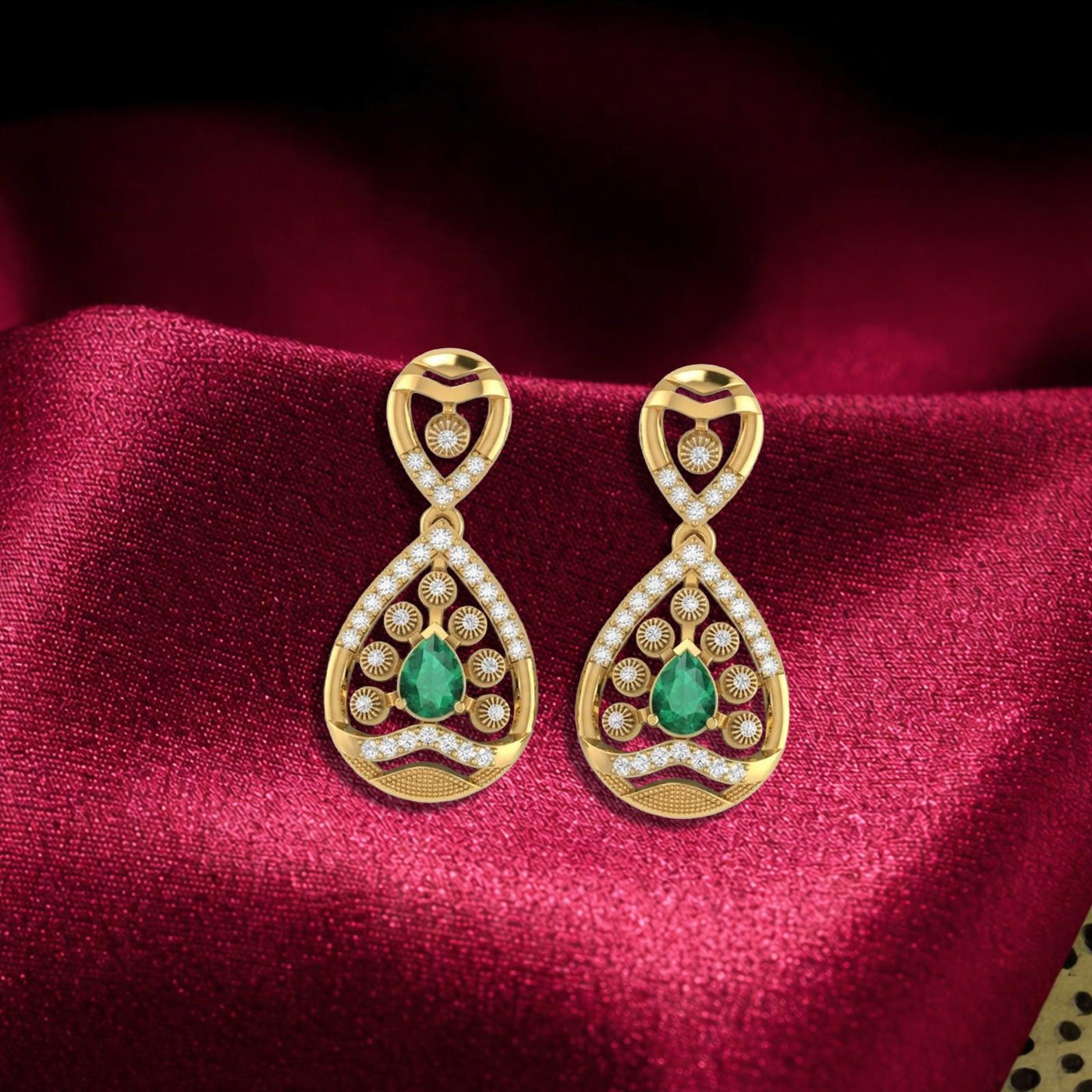 Pair of gold and diamond gemstone earrings on a red fabric background.