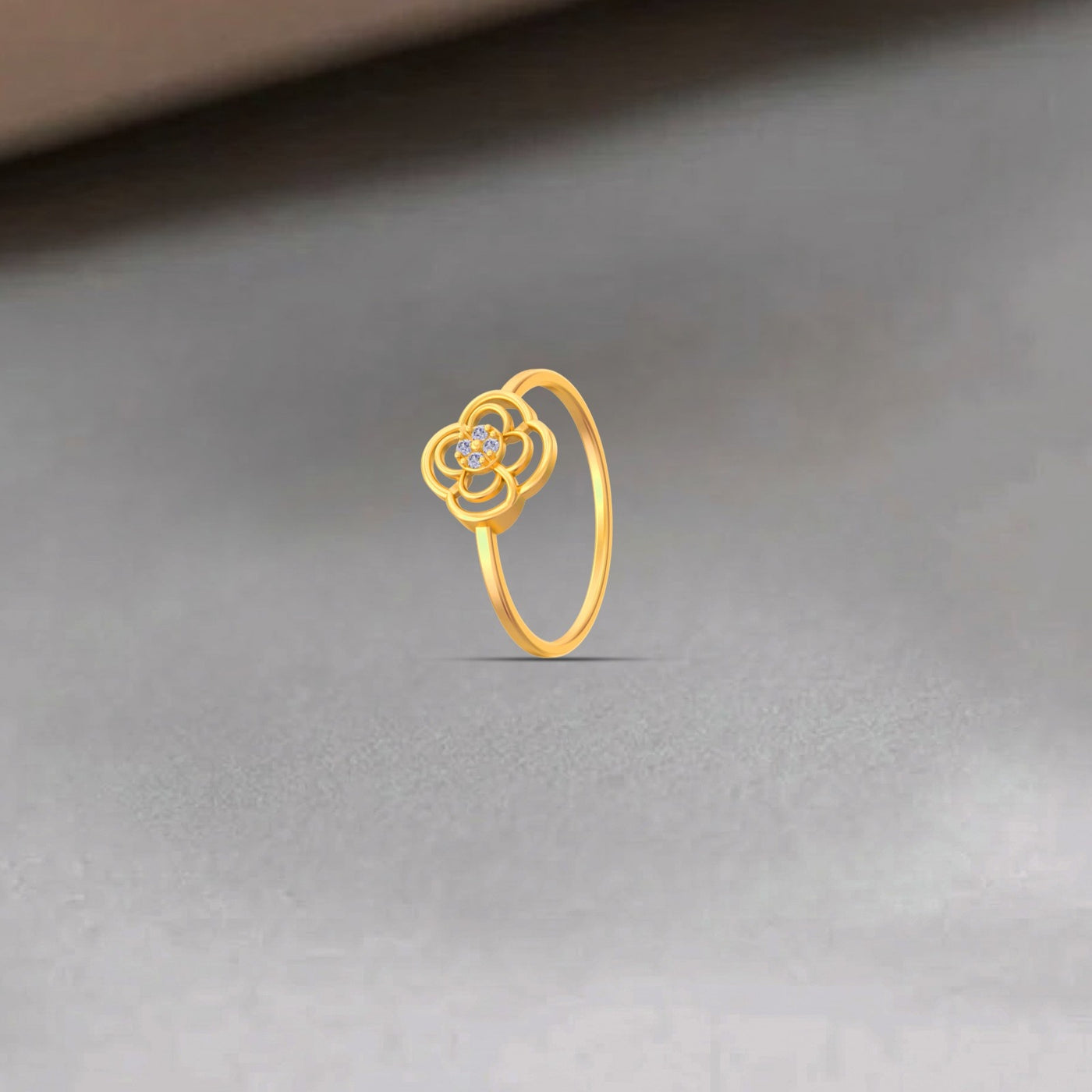Gold ring with a floral design on a gray background