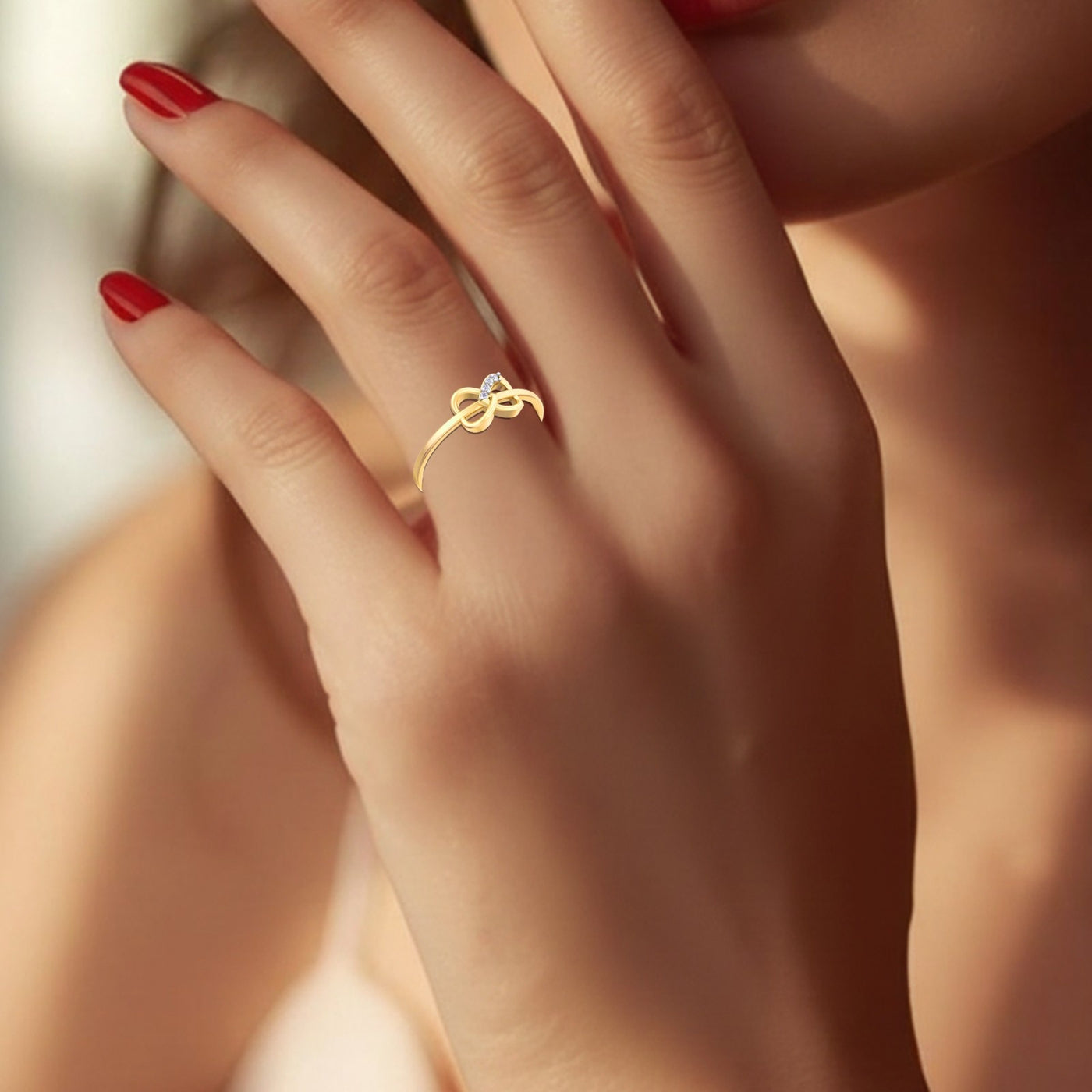 Close-up of a hand wearing a gold ring with a diamond on a blurred background