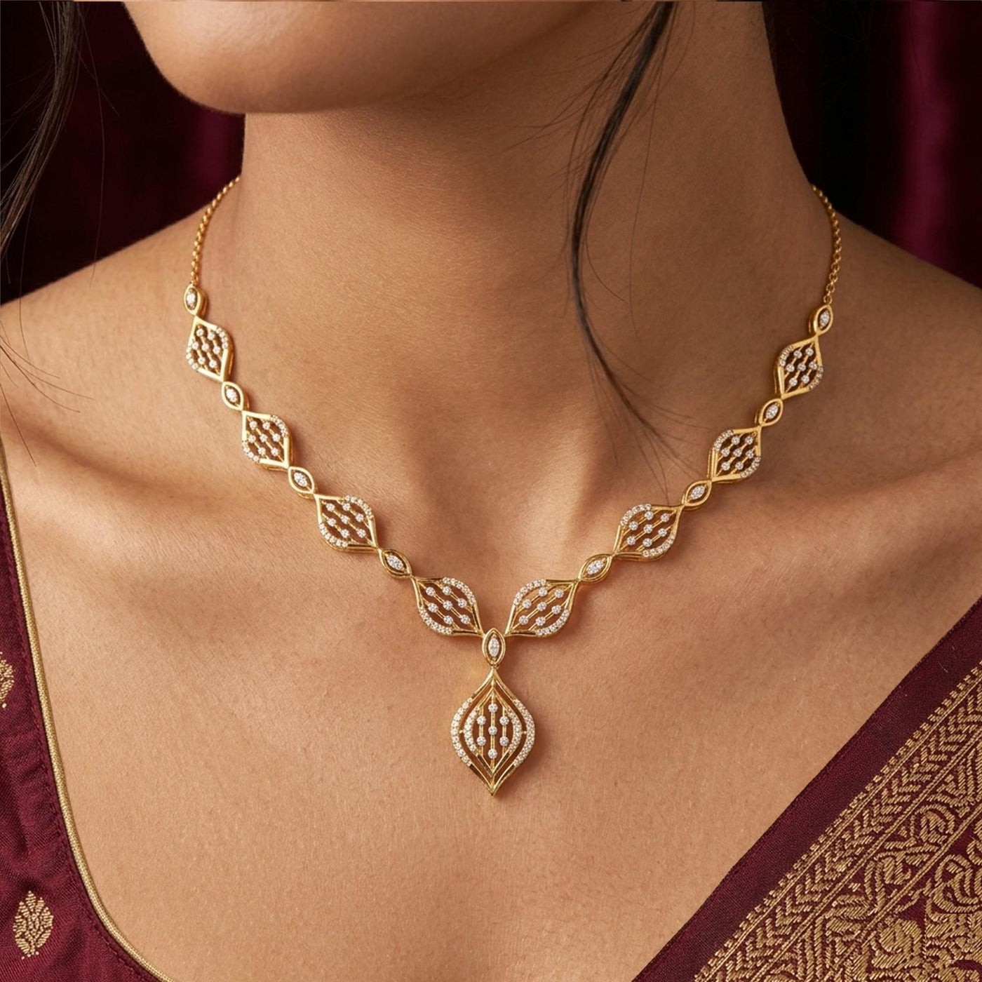 A gold and diamond necklace set, worn by a model in a maroon traditional outfit.