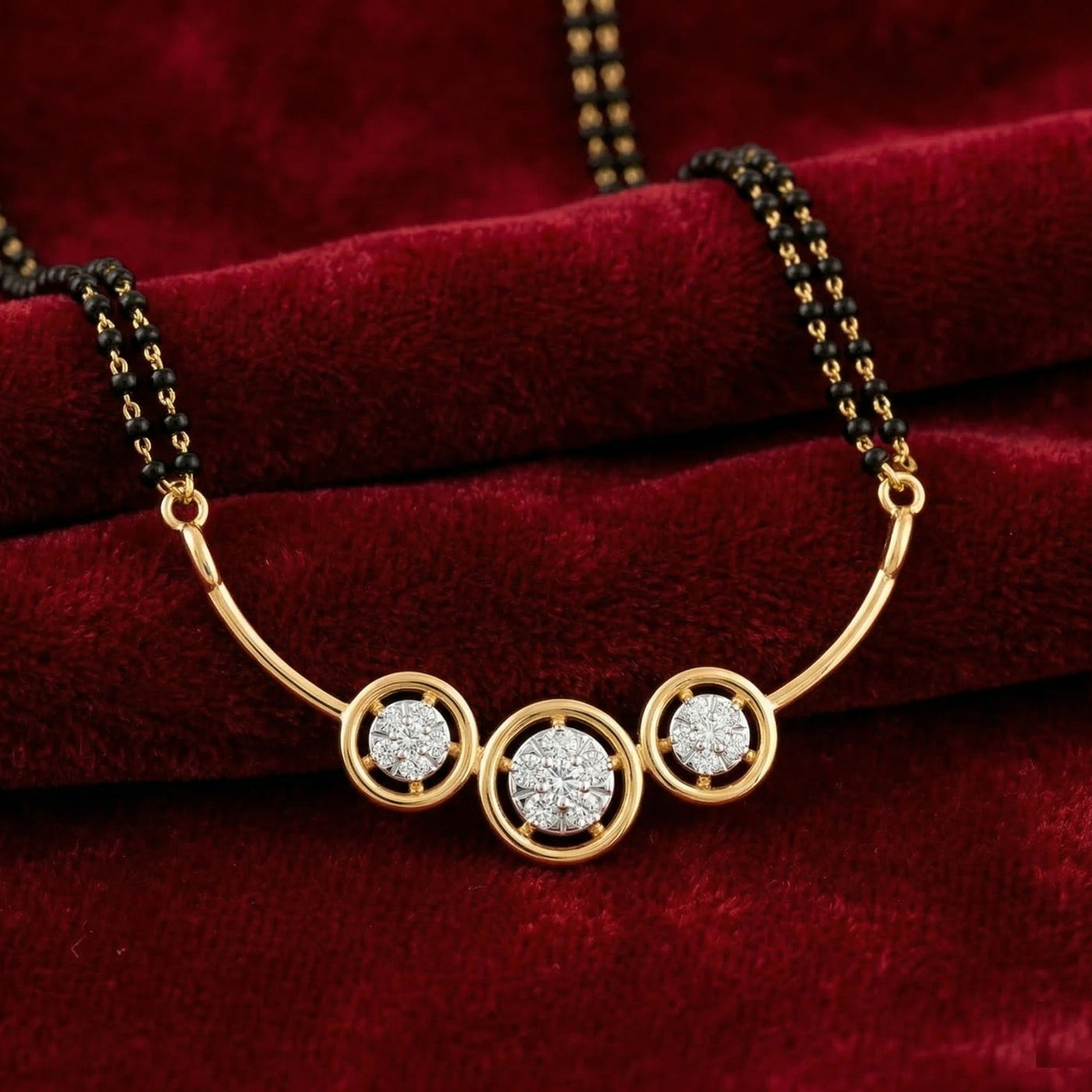 Gold mangalsutra with three circular diamond  on a red velvet background