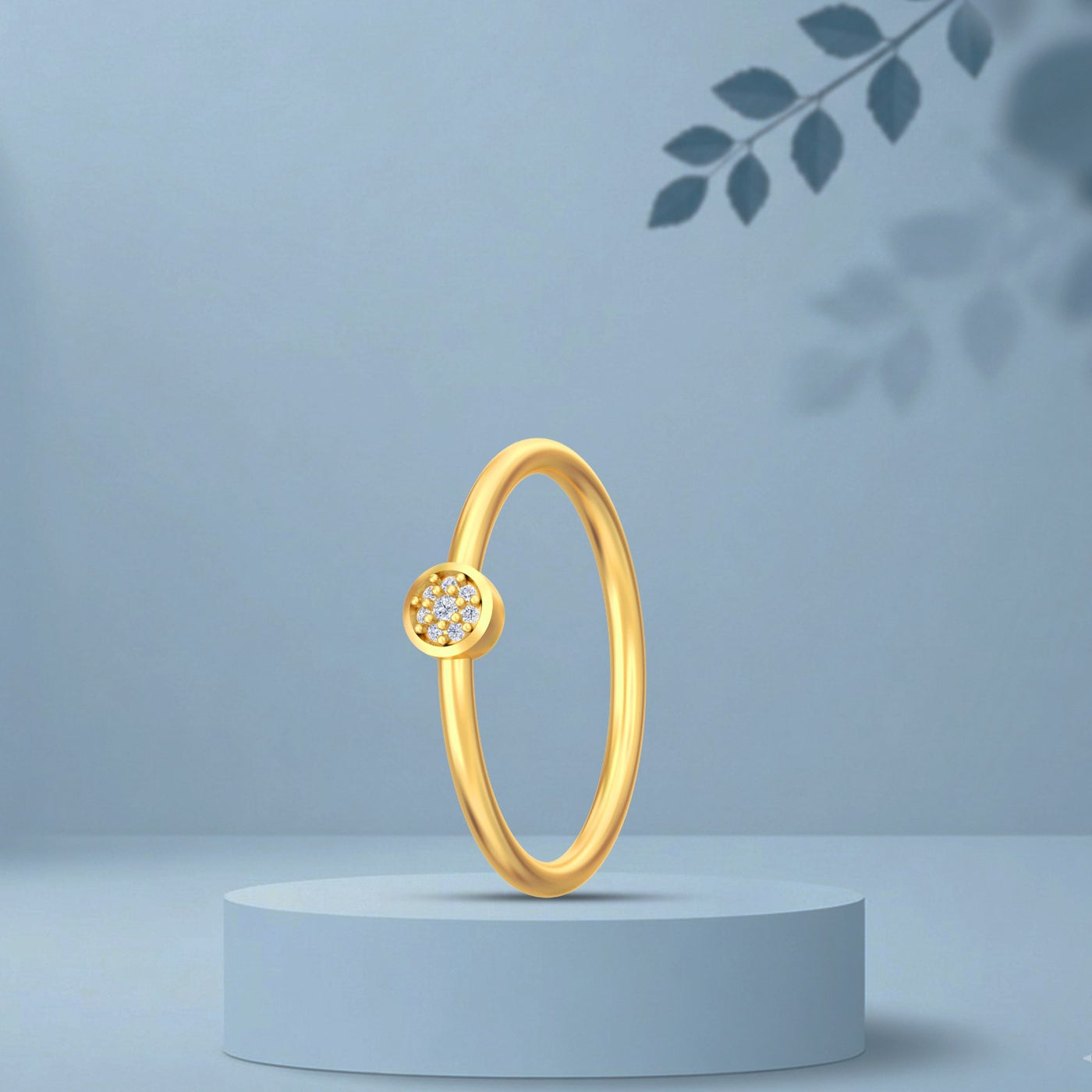 Gold ring with a small diamond on a light blue pedestal against a light blue background