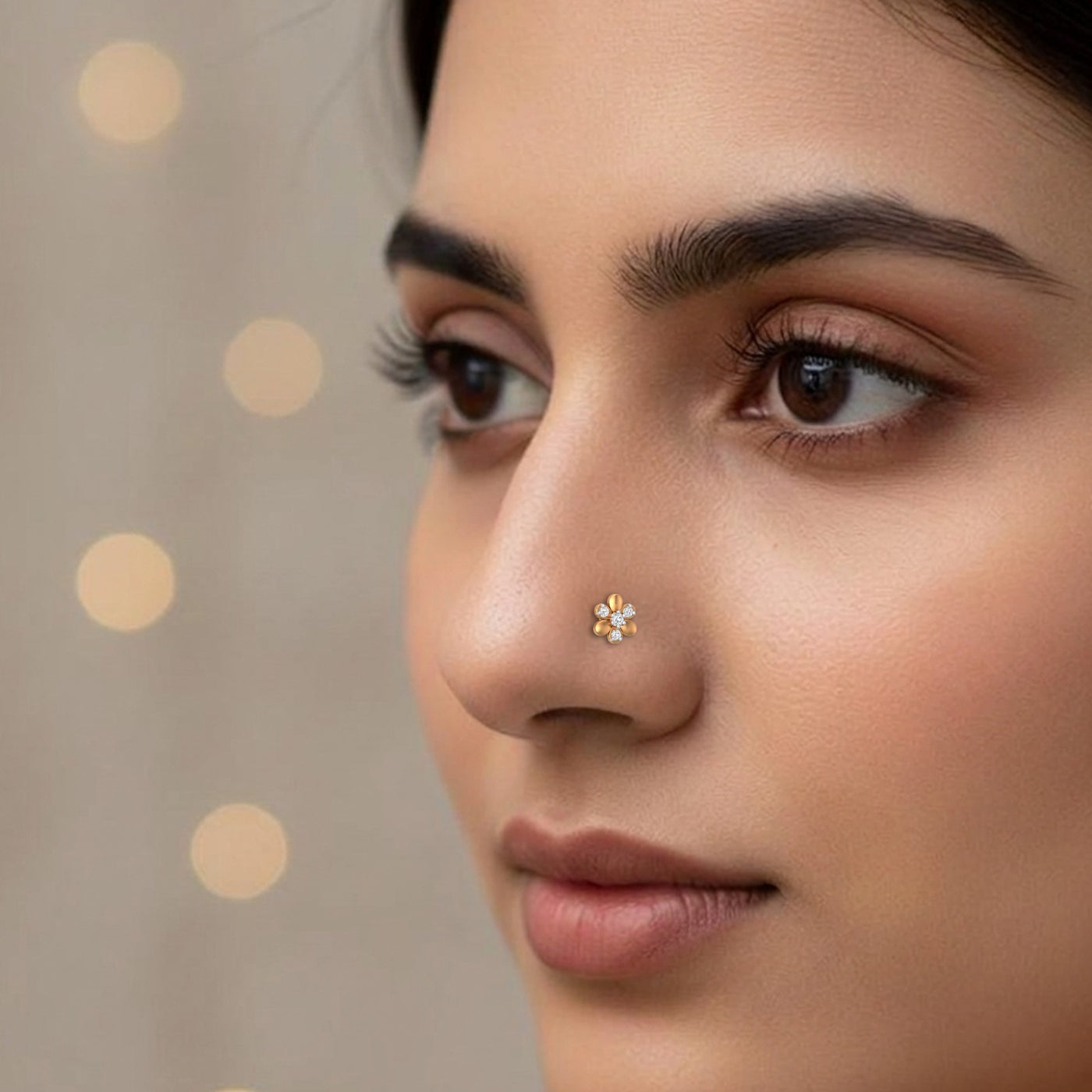 Close-up of a woman's face with a nose pin against a neutral background