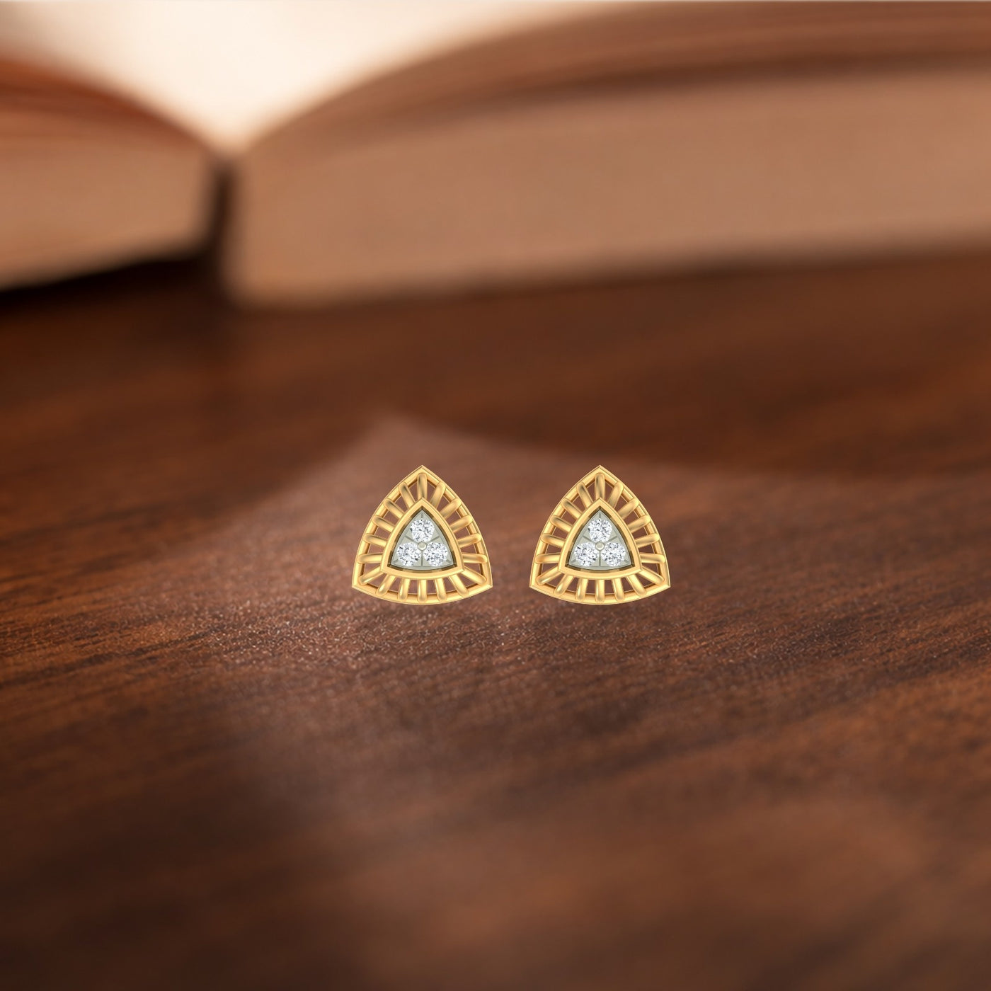 Gold and diamond triangle-shaped earrings on a wooden surface